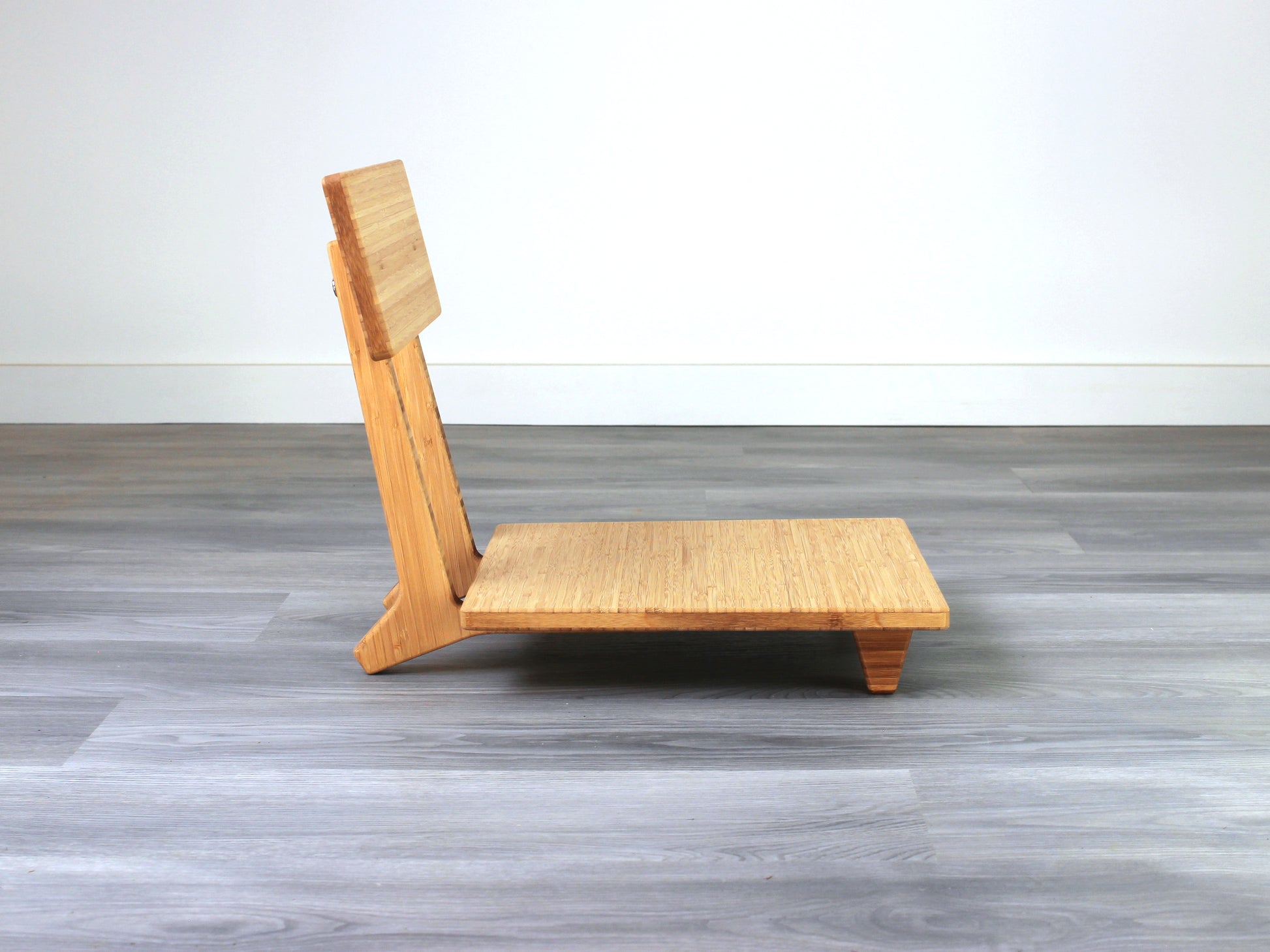 Sustainable bamboo floor chair featuring a low-profile design and sturdy backrest, perfect for meditation and Japanese-style low tables. Placed on grey floor and white back wall.
floor chair
chabudai
contemporary
low seating 
floor chair with back 
ergonomic