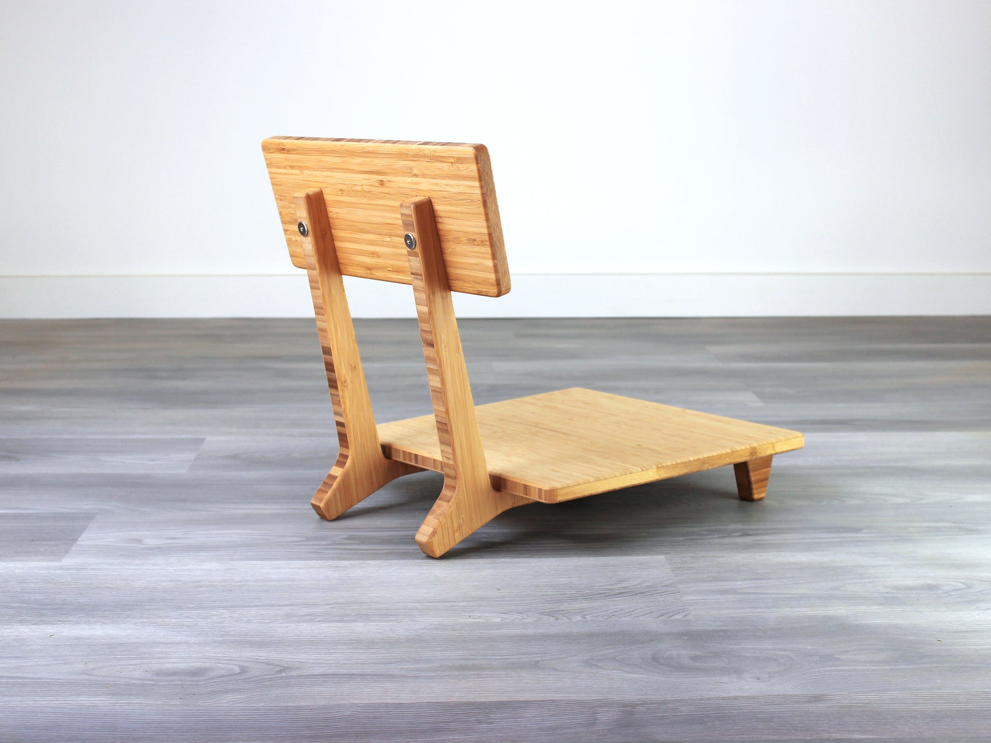 Sustainable bamboo floor chair featuring a low-profile design and sturdy backrest, perfect for meditation and Japanese-style low tables. Placed on grey floor and white back wall.
floor chair
chabudai
contemporary
low seating 
floor chair with back 
ergonomic