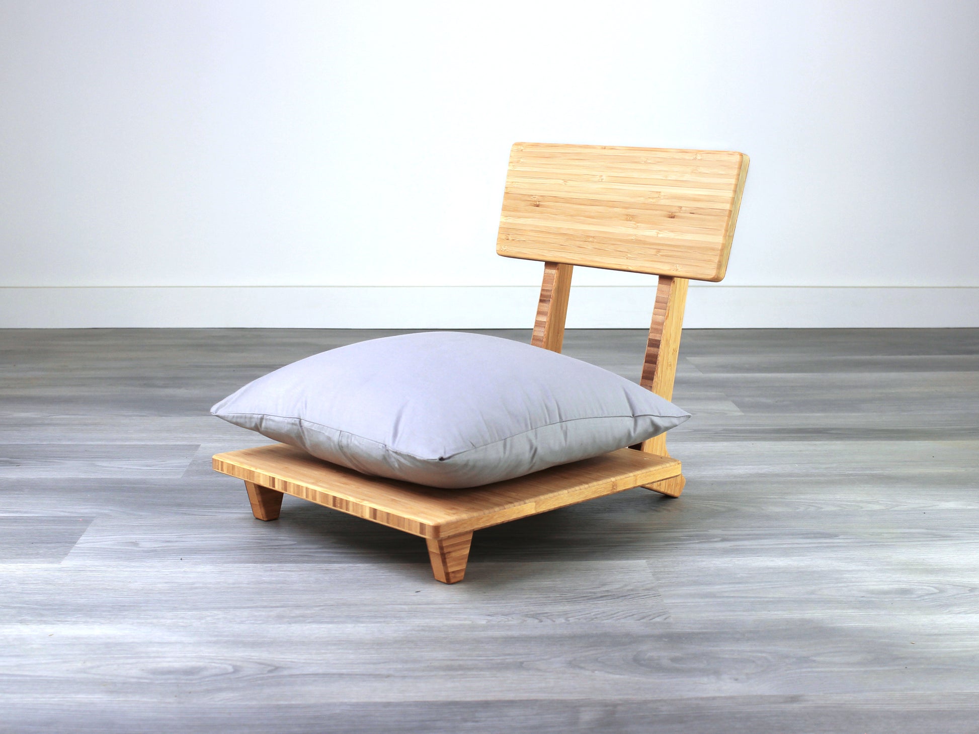 Sustainable bamboo floor chair featuring a low-profile design and sturdy backrest, perfect for meditation and Japanese-style low tables. Placed on grey floor and white back wall.
floor chair
chabudai
contemporary
low seating 
floor chair with back 
ergonomic 
pillow chair