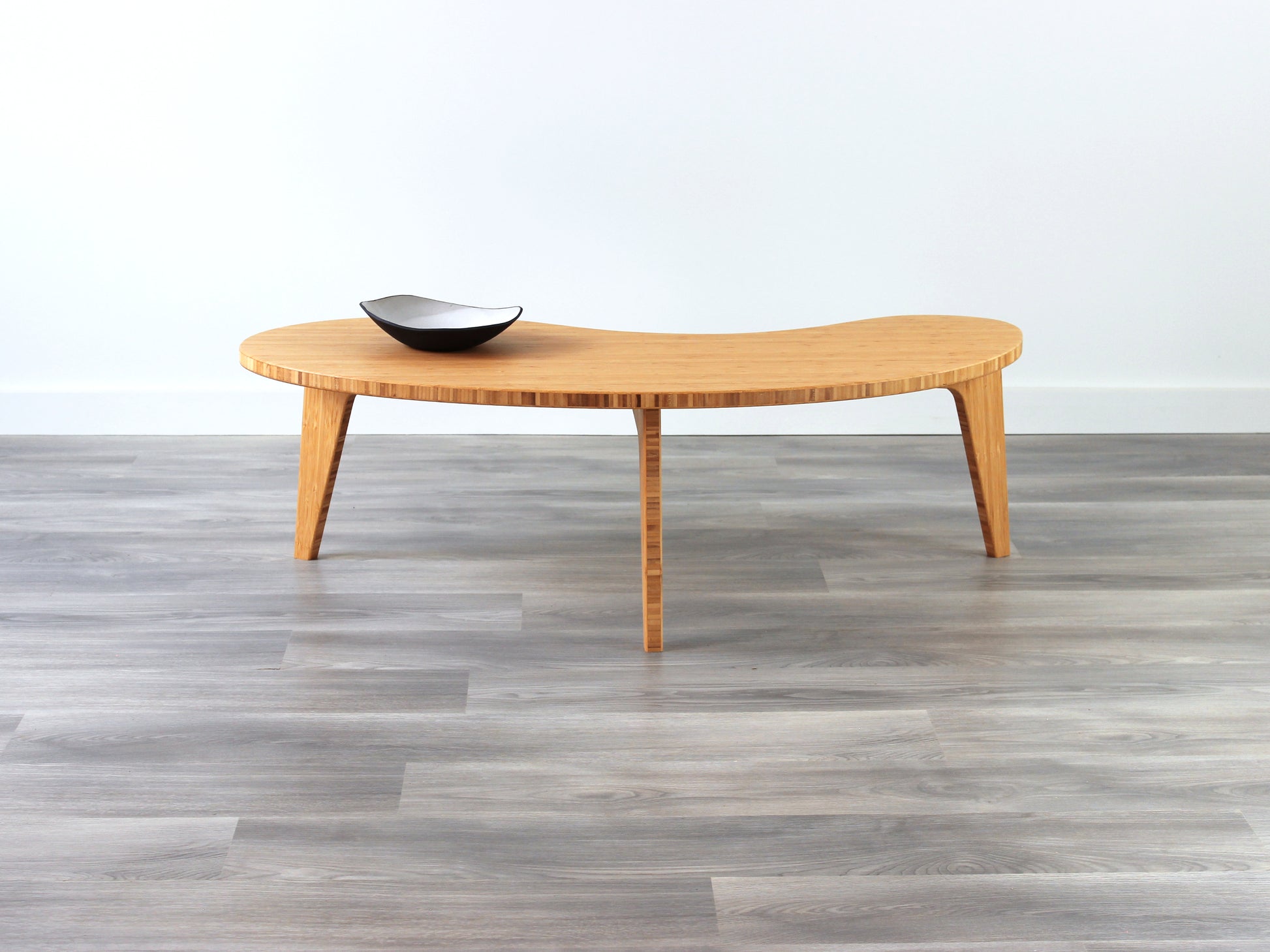 A kidney-shaped natural bamboo table, featuring a small black and white pottery vessel placed on top. Grey flooring with a white background. 
mid century modern low table
midcentury modern coffee table
floor table
japan coffee table
japan furniture
japan table
kidney coffee table 
bamboo low table
