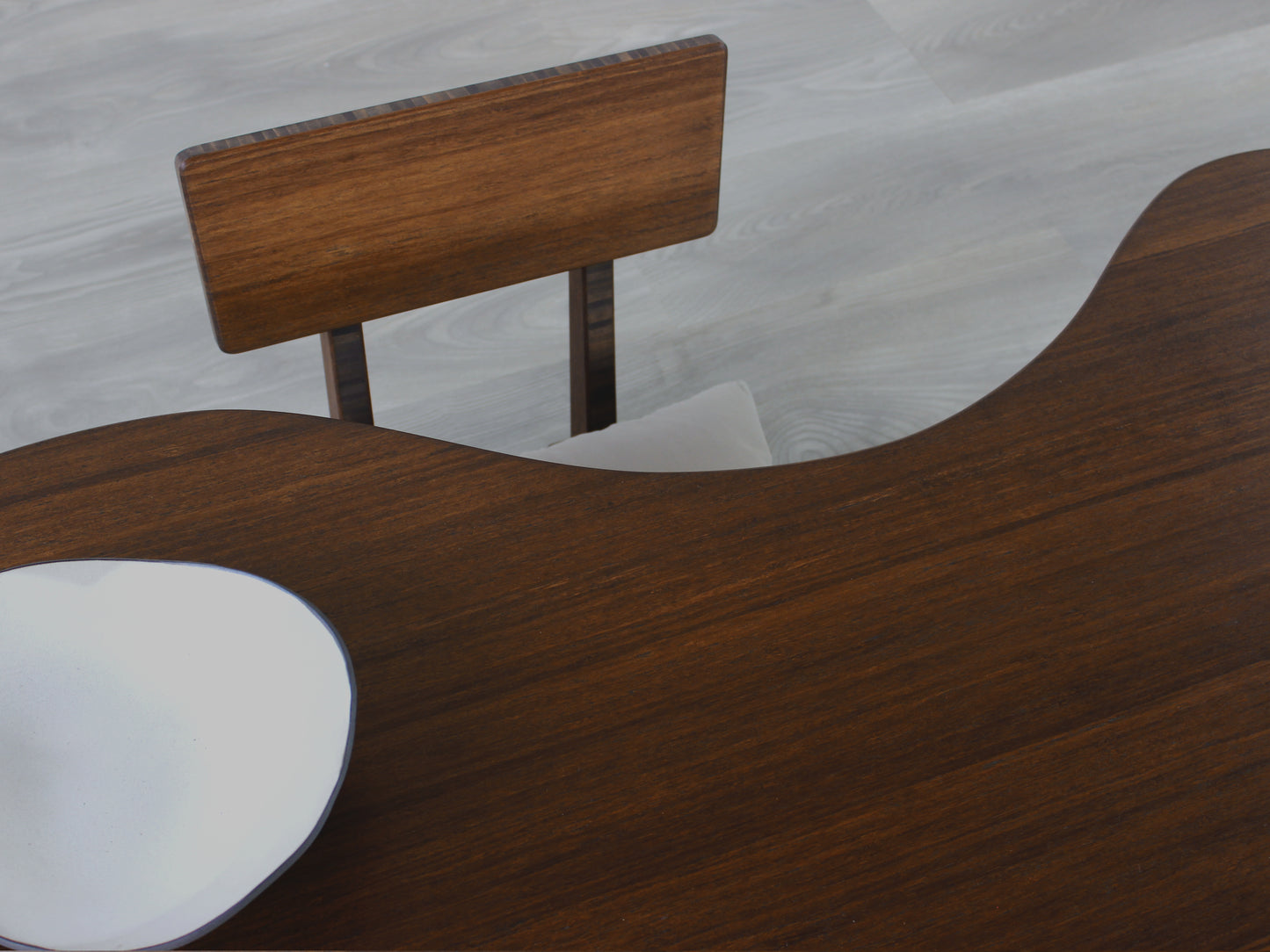 A kidney-shaped walnut bamboo table, featuring a small black and white pottery vessel placed on top. Grey flooring with a Floor Chair Comfort set underneath.
mid century modern low table
midcentury modern coffee table
floor table
japan coffee table
japan furniture
japan table
kidney coffee table
bamboo low table