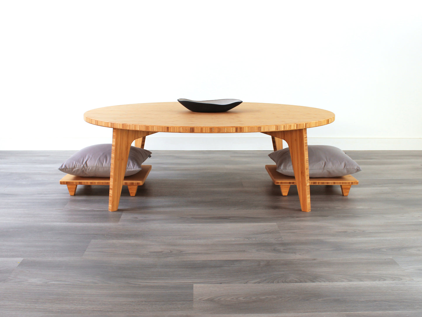 Large Circle Low Table with a natural bamboo finish and midcentury modern design. Two Floor Chair posture with grey pillows are set at the table. Small black pottery vessel placed on table top.
Japandi, minimalist, mid-century, Japanese inspired, modern, contemporary, clean lines, organic design, sustainable bamboo, renewable bamboo, solid bamboo, eco-friendly furniture, natural materials, natural-based finish