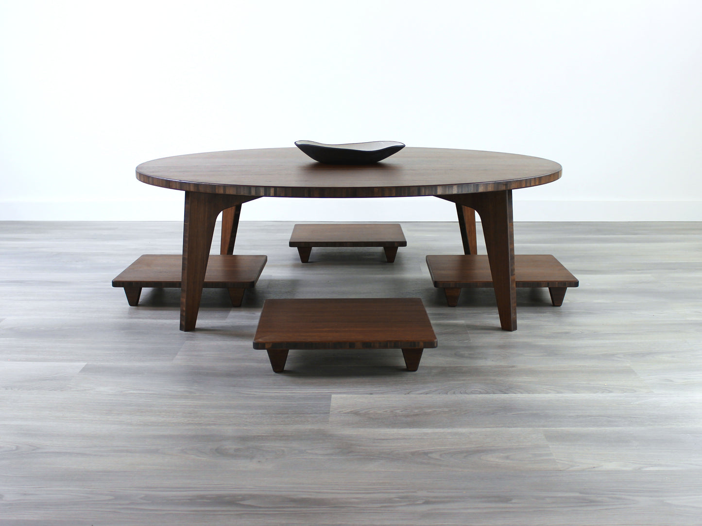 Large Circle Low Table with a walnut bamboo finish and midcentury modern design. Floor Chair Posture with a grey pillow are set at the table, small black pottery vessel placed on table top.
Japandi, minimalist, mid-century, Japanese inspired, modern, contemporary, clean lines, organic design, sustainable bamboo, renewable bamboo, solid bamboo, eco-friendly furniture, natural materials, natural-based finish