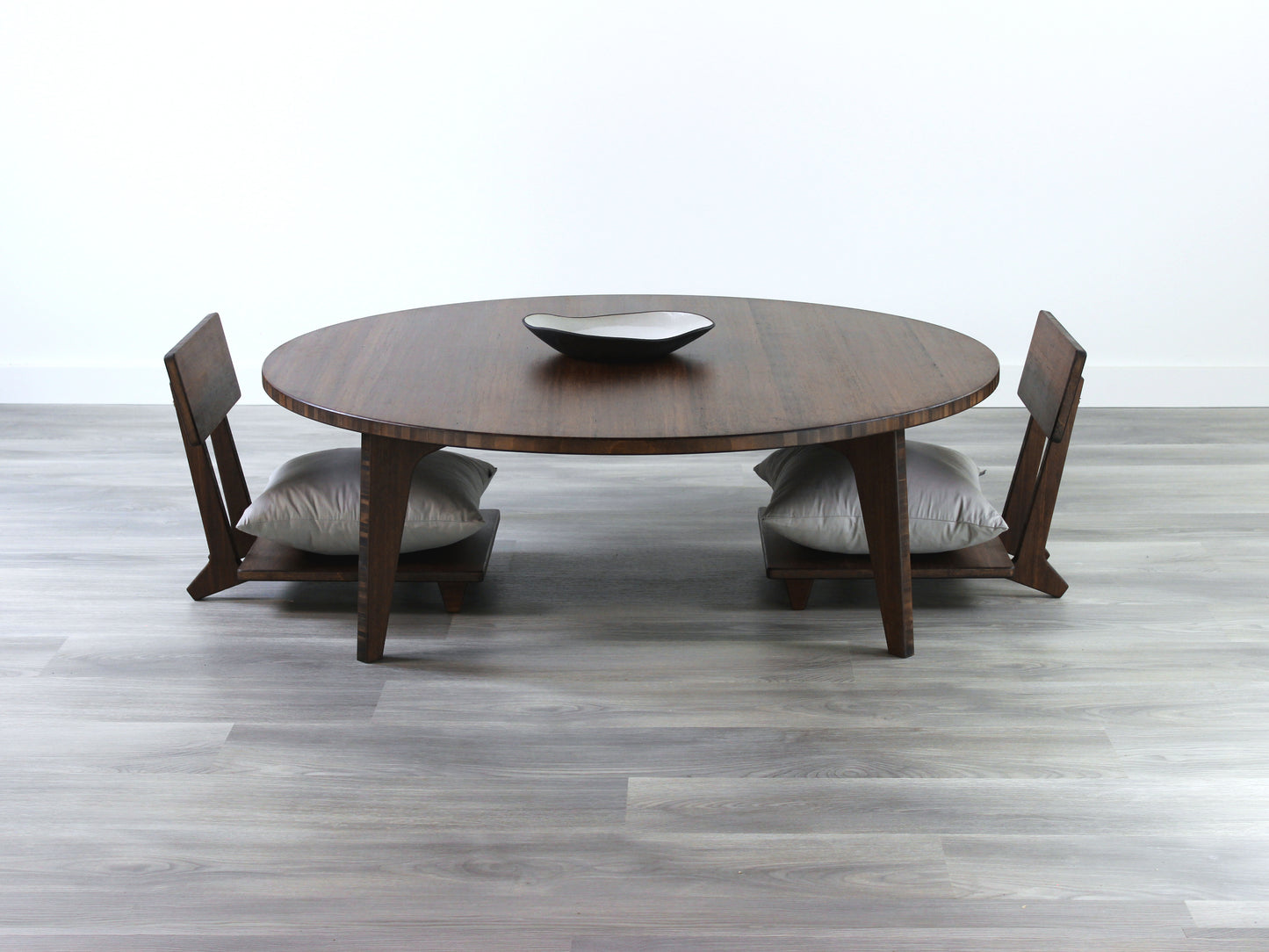 Large Circle Low Table with a walnut bamboo finish and midcentury modern design. Two Floor Chair Comfort with grey pillows are set at the table. Small black pottery vessel placed on table top.
Japandi, minimalist, mid-century, Japanese inspired, modern, contemporary, clean lines, organic design, sustainable bamboo, renewable bamboo, solid bamboo, eco-friendly furniture, natural materials, natural-based finish