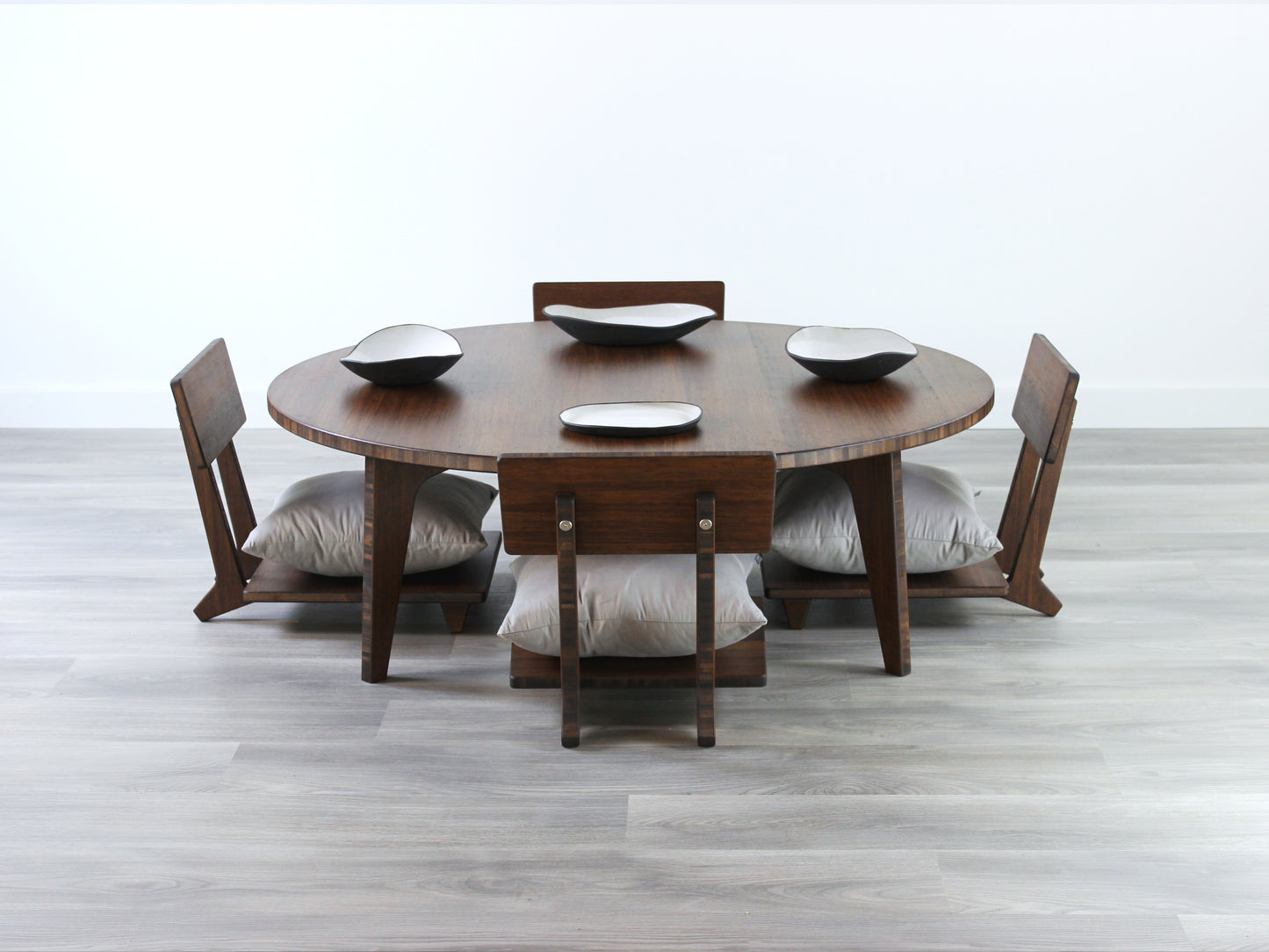 Large Circle Low Table with a walnut bamboo finish and midcentury modern design. Three Floor Chair Comfort with grey pillows are set at the table. Multiple Small black pottery vessels placed on table top.
Japandi, minimalist, mid-century, Japanese inspired, modern, contemporary, clean lines, organic design, sustainable bamboo, renewable bamboo, solid bamboo, eco-friendly furniture, natural materials, natural-based finish