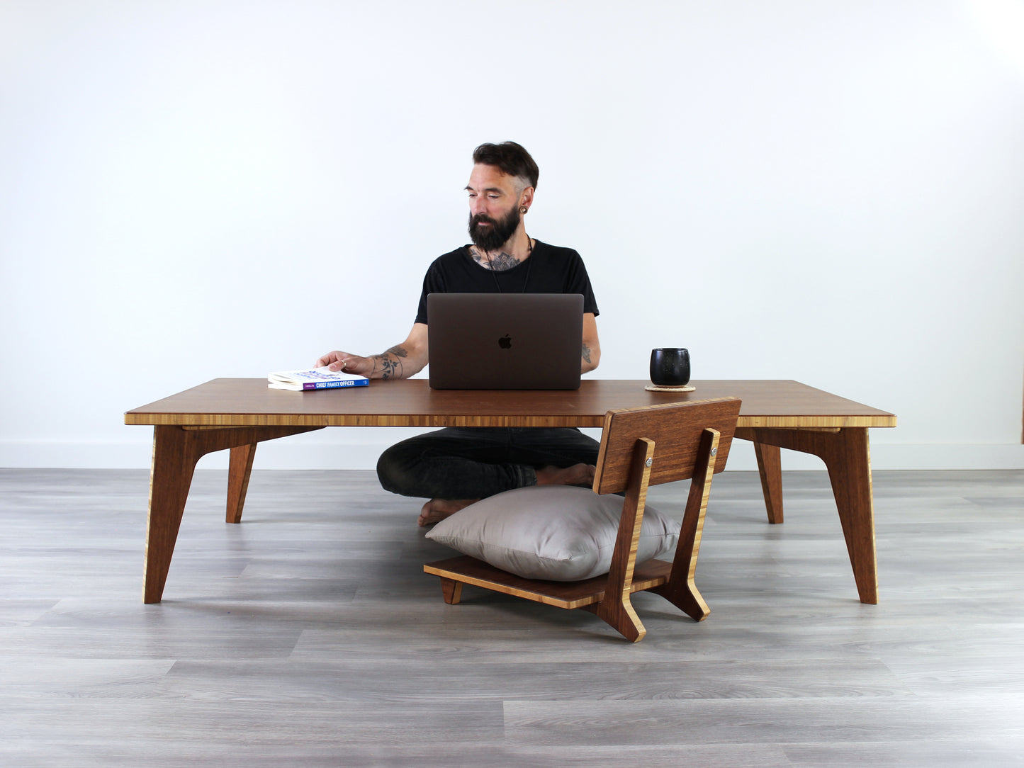 Large Rectangle Table Set - Chestnut. Set on a grey floor, against a white background. A person sitting in Floor Chair Posture working on a laptop. A black coffee mug on table top.
low table, coffee table, dining table, floor desk, floor chair, floor seating, low dining table, chabudai, tatami, kotatsu, minimalist, minimalist table,
modern, japanese low table, japanese table, kotatsu, large coffee table,
large dining table