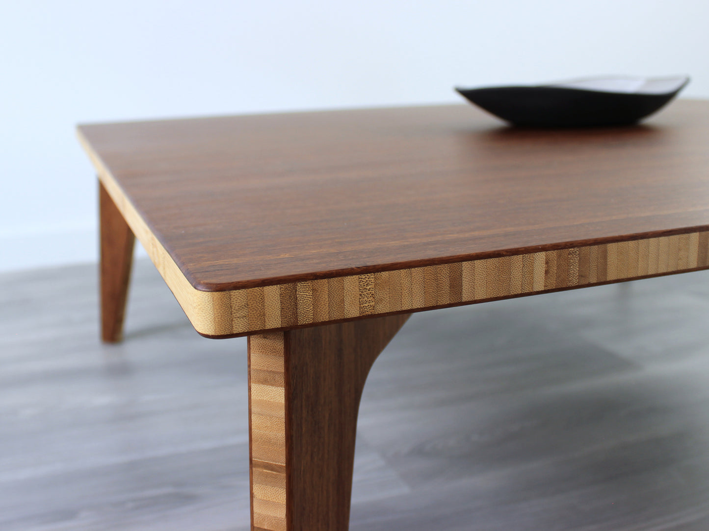 Large square floor table in bamboo with a chestnut color finish, featuring a Japandi style design, set on a grey floor with a white background. A small black pottery vessel sets on top.
Square low table
japanese furniture
japanese low table
low coffee table
low dining table
low table
mid century
minimalist
minimalist table
modern
chabudai