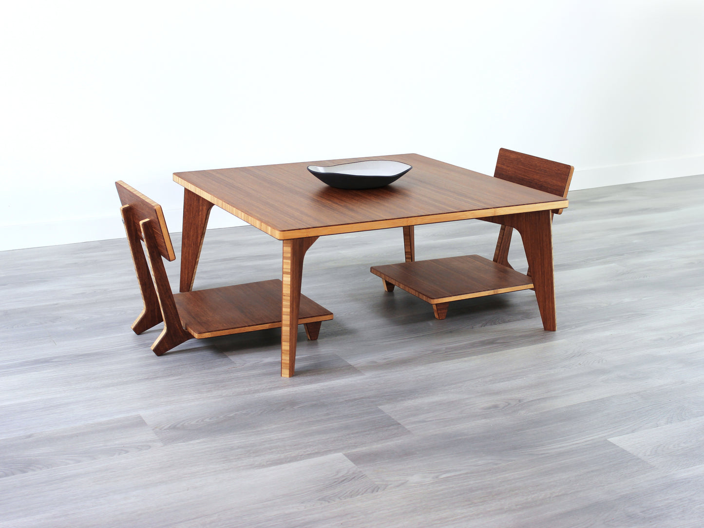 Small Square Table Set in chestnut finish. Two Floor Chair Comfort are placed below. A small black pottery vessel is placed on top of the table.
sustainable bamboo, renewable bamboo, solid bamboo, eco-friendly furniture, zero-waste, carbon neutral, natural materials, natural-based finish, repairable furniture