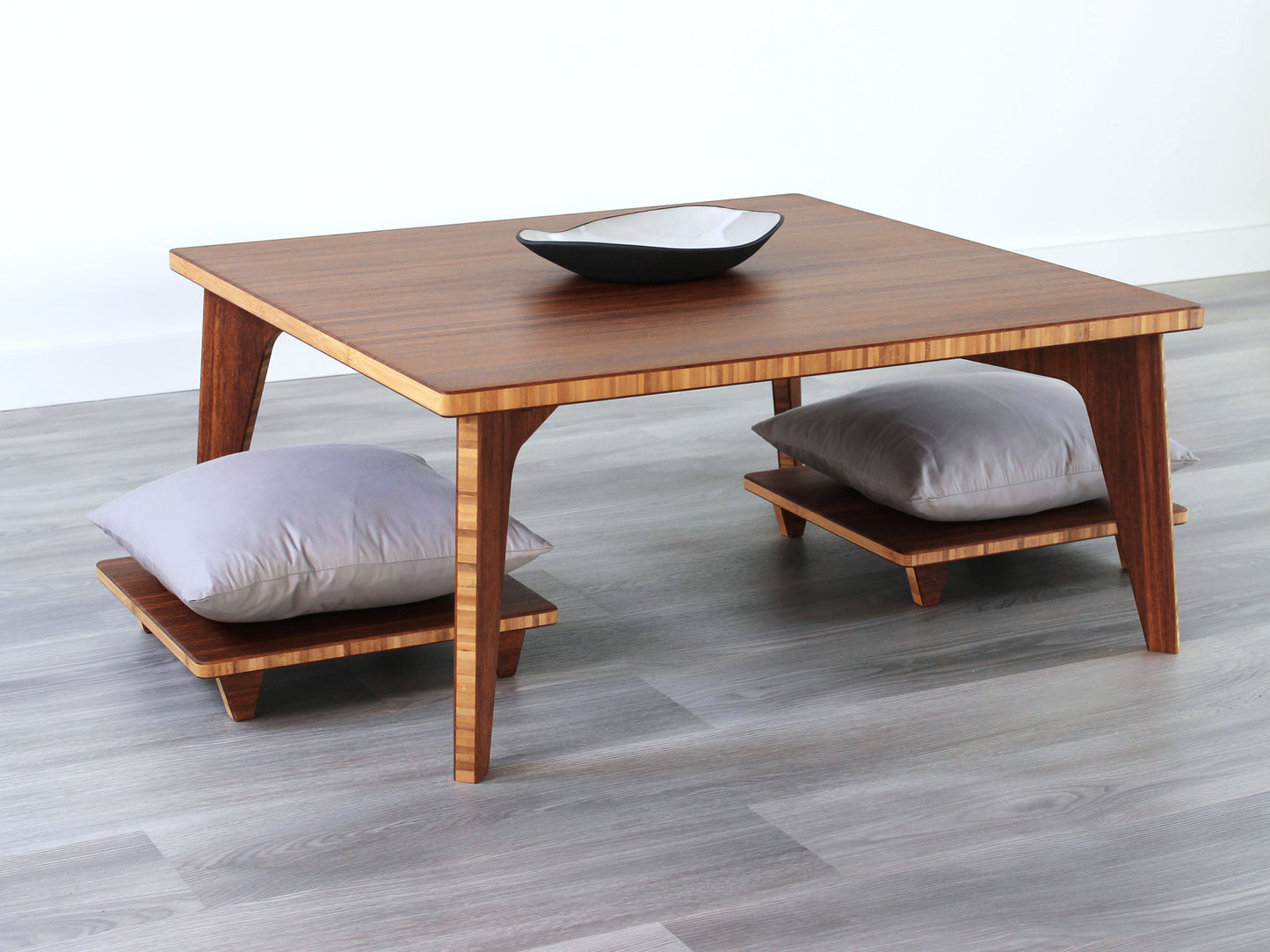 Small Square Table Set in chestnut finish. Two Floor Chair Posture are placed below. A small black pottery vessel is placed on top of the table.
sustainable bamboo, renewable bamboo, solid bamboo, eco-friendly furniture, zero-waste, carbon neutral, natural materials, natural-based finish, repairable furniture