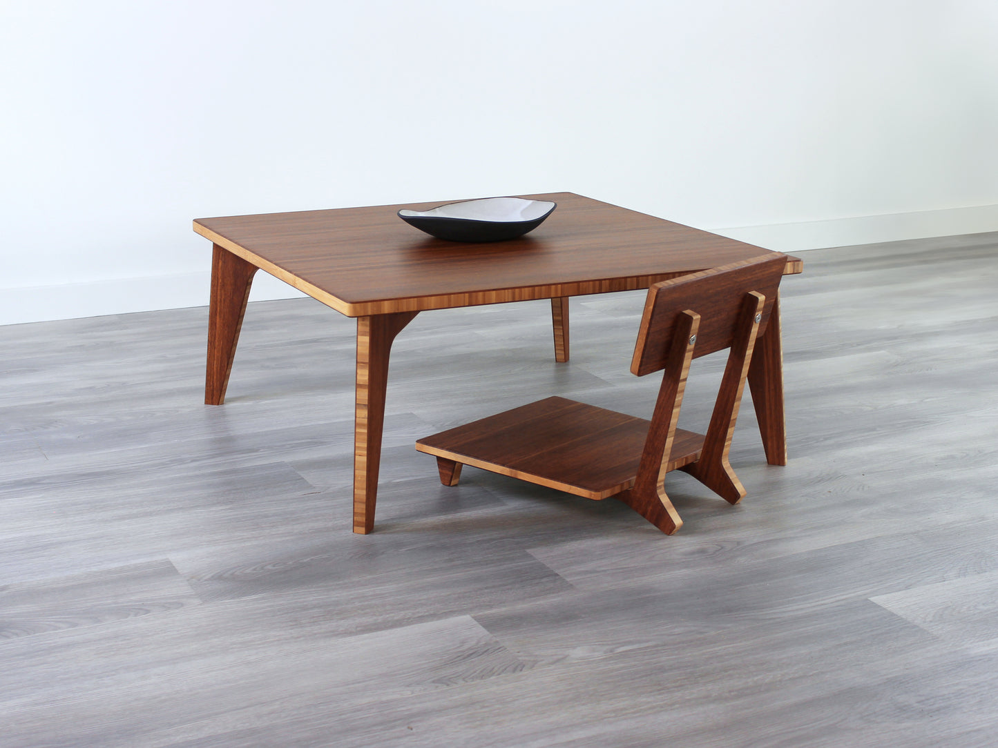 Small Square Table Set in chestnut finish. A Floor Chair Comfort are placed below. A small black pottery vessel is placed on top of the table.
sustainable bamboo, renewable bamboo, solid bamboo, eco-friendly furniture, zero-waste, carbon neutral, natural materials, natural-based finish, repairable furniture