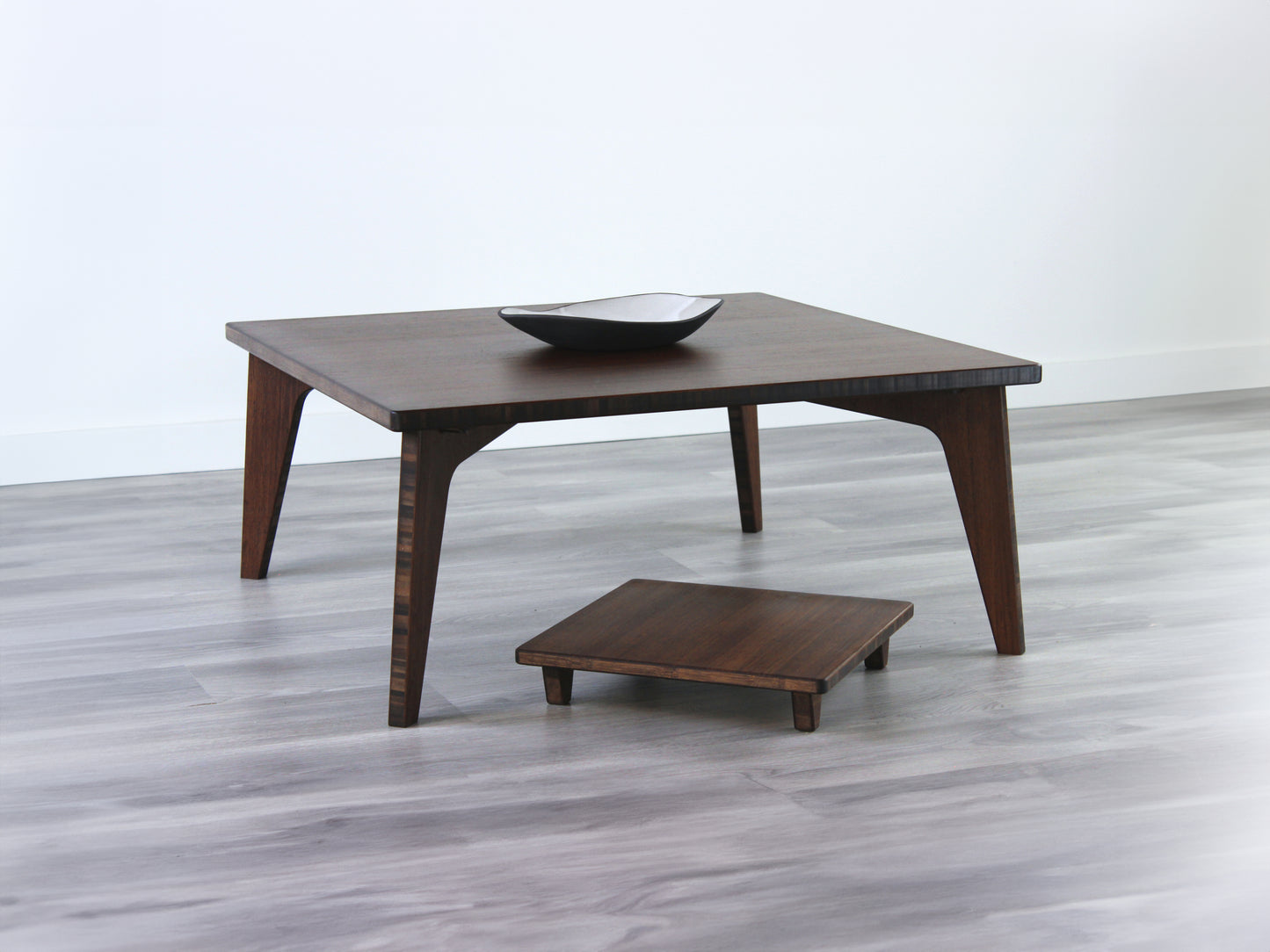 Small Square Table Set in walnut finish. A Floor Chair Posture are placed below. A small black pottery vessel is placed on top of the table.
sustainable bamboo, renewable bamboo, solid bamboo, eco-friendly furniture, zero-waste, carbon neutral, natural materials, natural-based finish, repairable furniture
