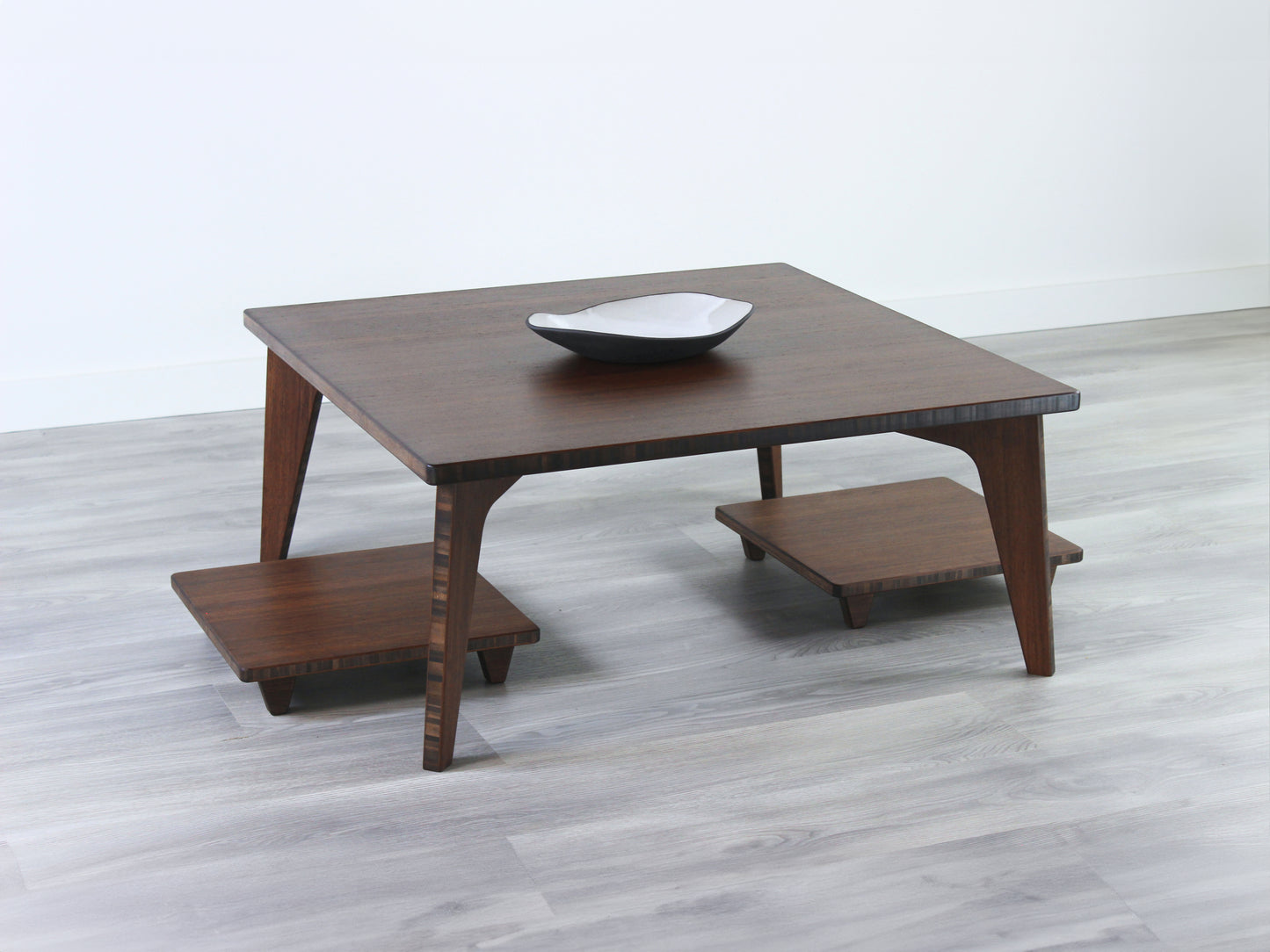 Small Square Table Set in walnut finish. Two Floor Chair Posture are placed below. A small black pottery vessel is placed on top of the table.
sustainable bamboo, renewable bamboo, solid bamboo, eco-friendly furniture, zero-waste, carbon neutral, natural materials, natural-based finish, repairable furniture