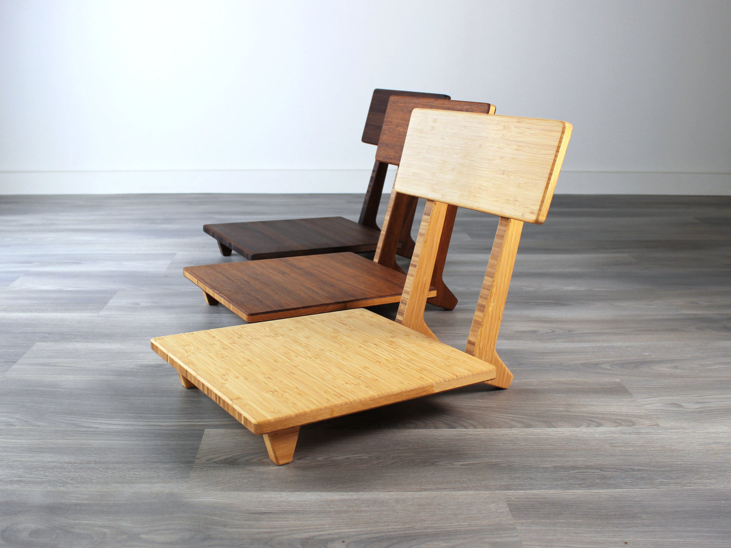 Three Floor Chair Comfort products, low seating to support posture and features a contemporary and ergonomic design. Natural, Chestnut, and Walnut finish available.