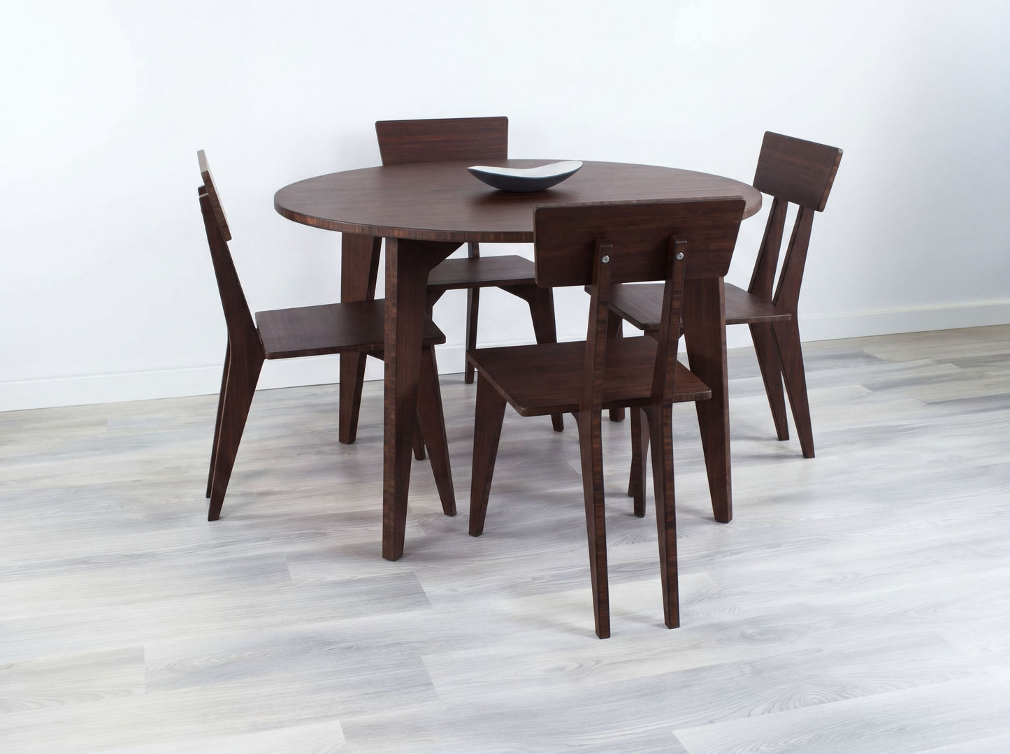 Bamboo dining table with four chairs on a light wooden floor.