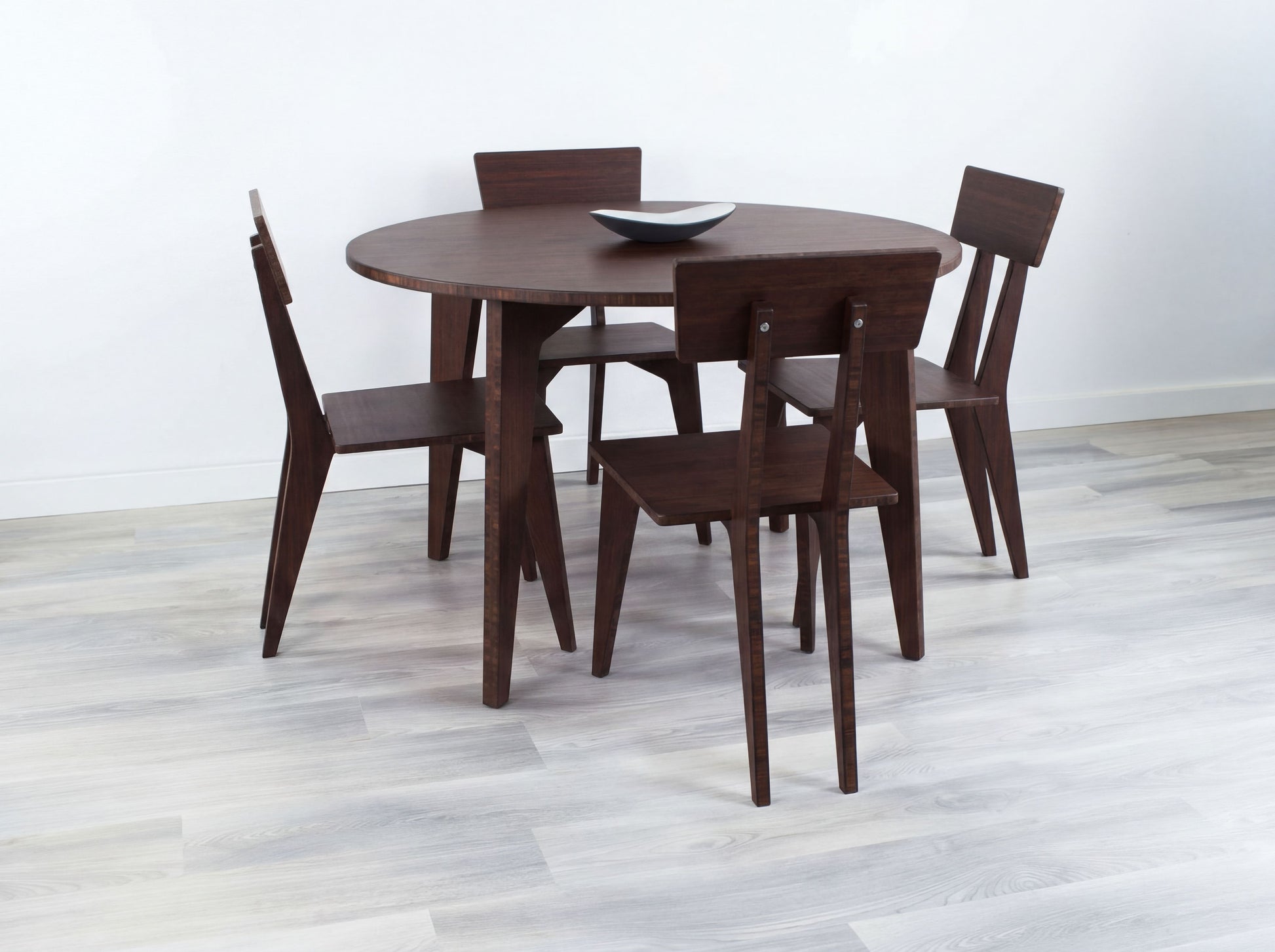 Bamboo dining table with four chairs on a light wooden floor.