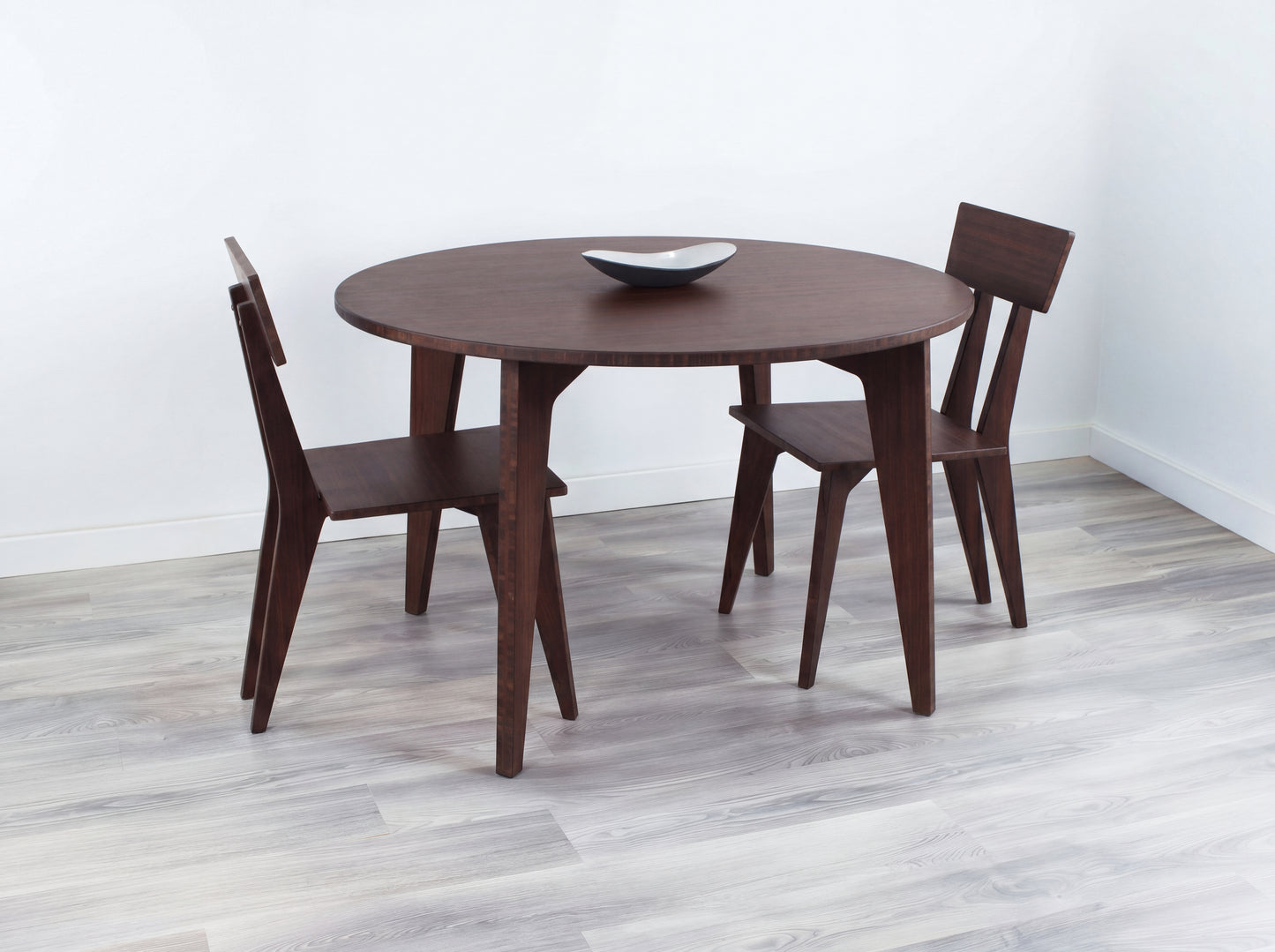 Bamboo dining table with four chairs in a minimalistic room.