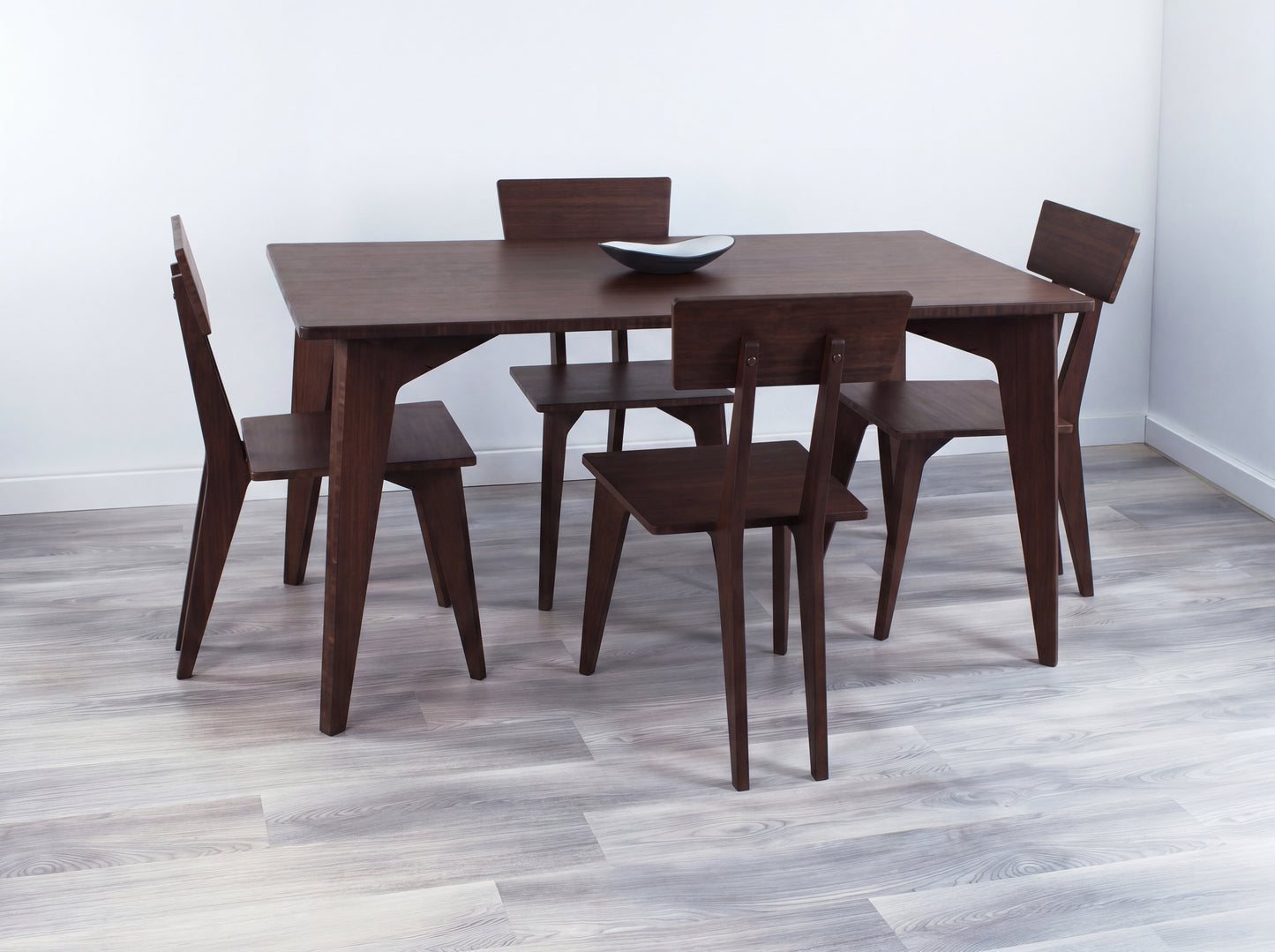 Bamboo dining table with four chairs in a minimalistic room.