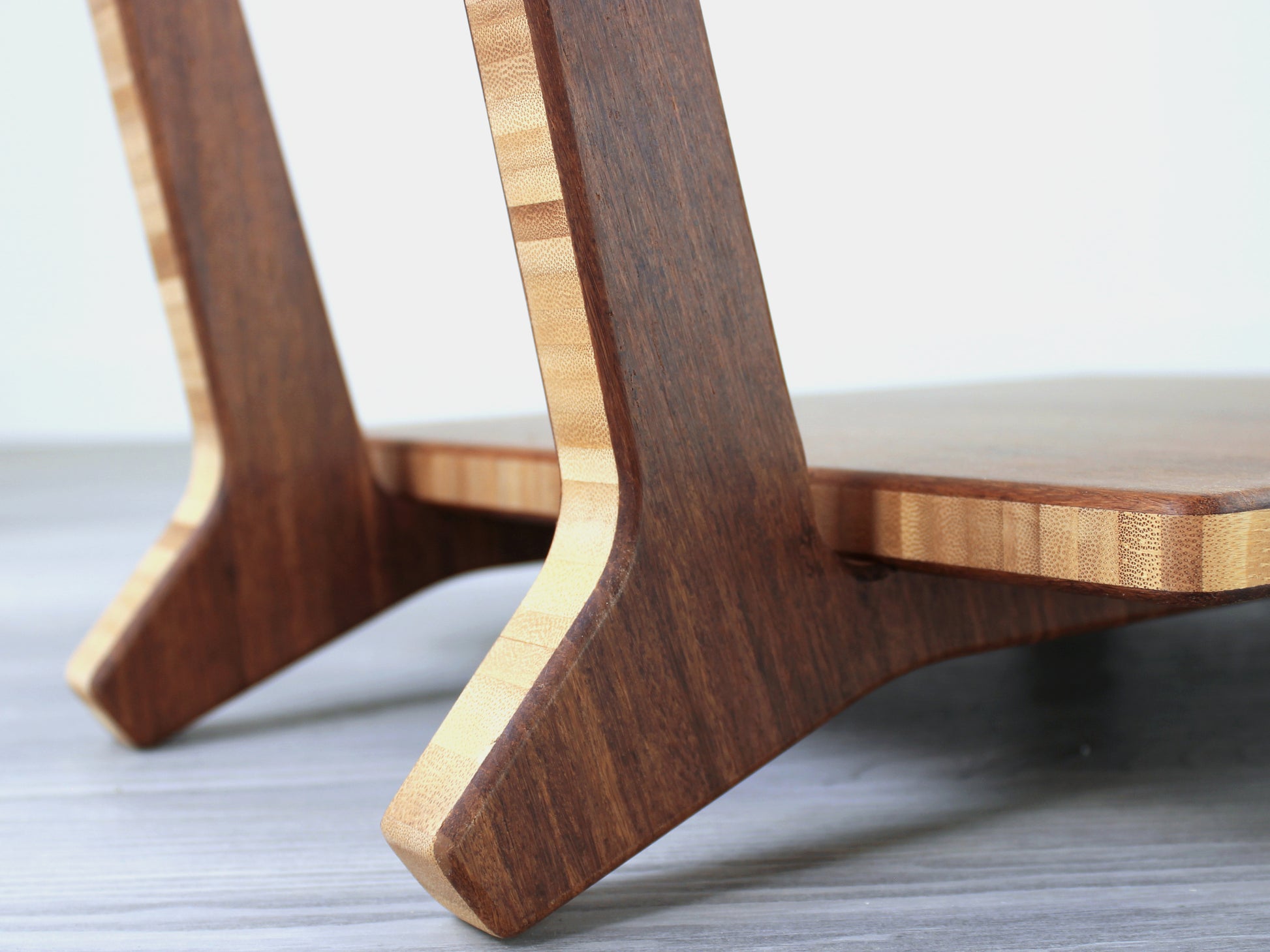 Chestnut bamboo Floor Chair Comfort with a square seat and a vertical supporting structure, displayed on a grey floor and white wall behind. 

floor chair
chabudai
contemporary
low seating 
floor chair with back 
ergonomic 
posture support