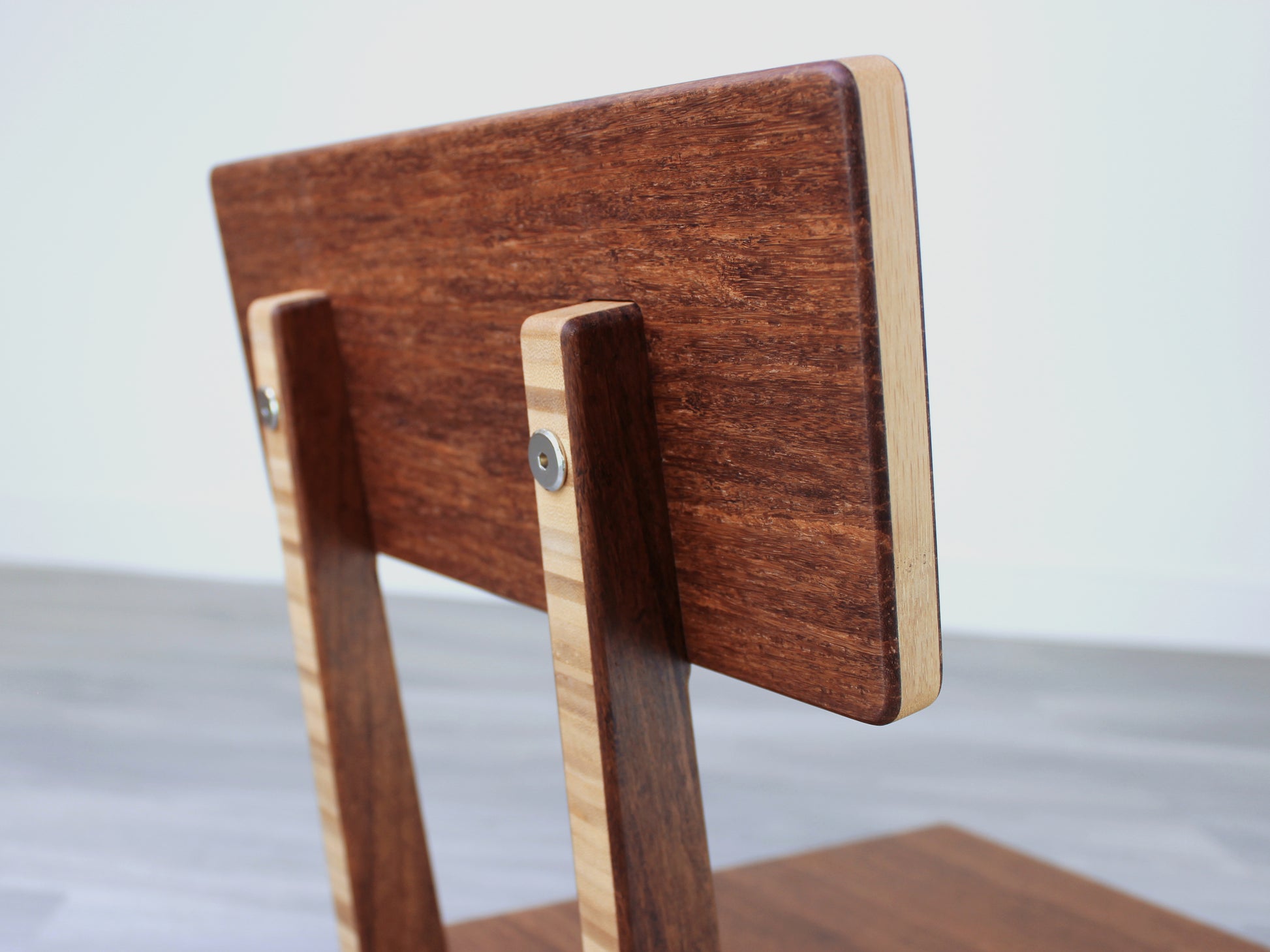 Chestnut bamboo Floor Chair Comfort with a square seat and a vertical supporting structure, displayed on a grey floor and white wall behind. 

floor chair
chabudai
contemporary
low seating 
floor chair with back 
ergonomic 
posture support