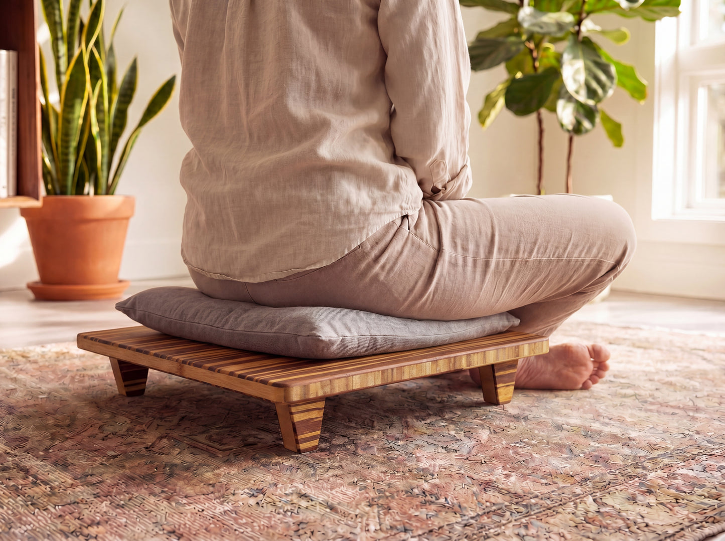 Person sitting on a bamboo meditation platform with cushions in a home setting.

Meditation Chair 
Japanese Tea Table 
Kotatsu
low chair
posture support 
ergonomic 
minimilist 