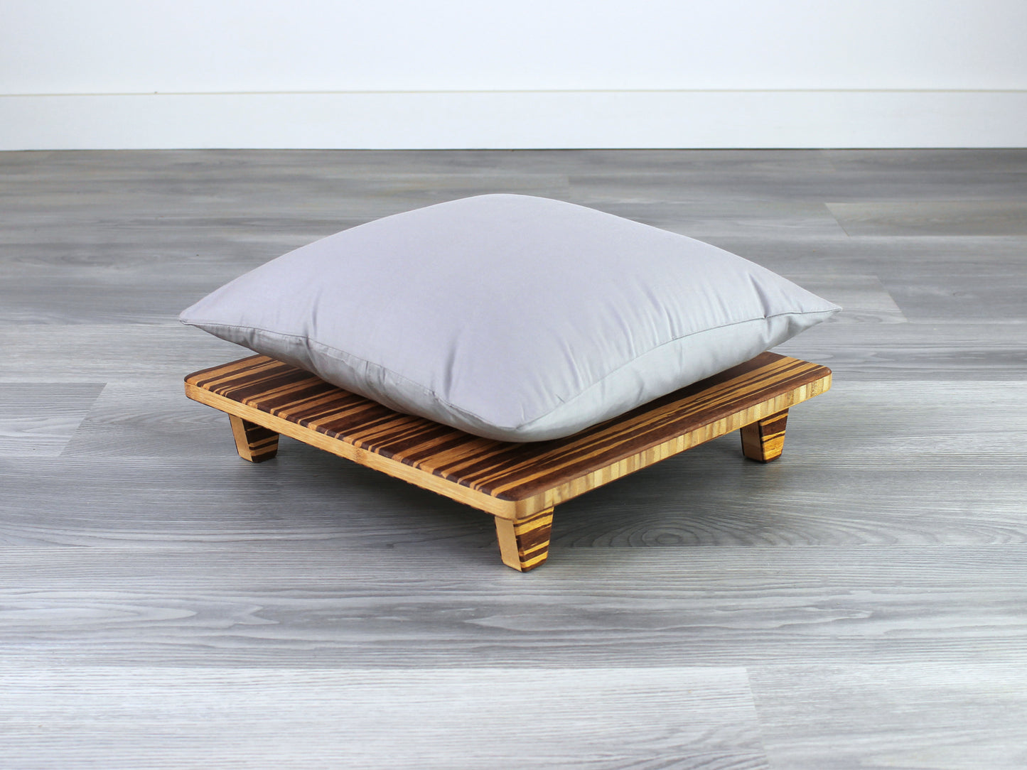 Tiger Floor Chair Posture, placed on a grey floor and a white wall background. Grey pillow placed on top. 

Meditation Chair 
Japanese Tea Table 
Kotatsu
low chair
posture support 
ergonomic 
minimilist
pillow lift