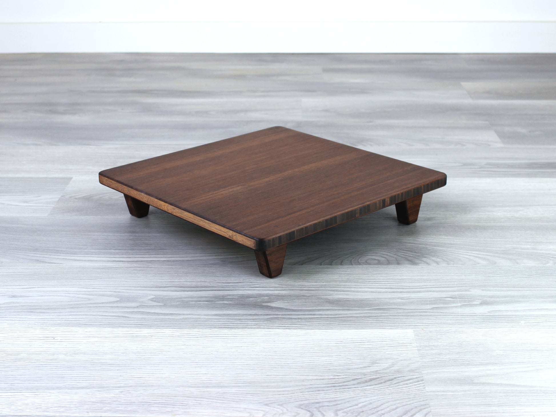 Walnut Floor Chair Posture, placed on a grey floor and a white wall background. 

Meditation Chair 
Japanese Tea Table 
Kotatsu
low chair
posture support 
ergonomic 
minimilist