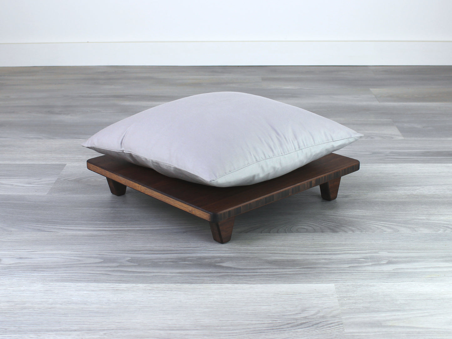 Walnut Floor Chair Posture, placed on a grey floor and a white wall background. Grey pillow placed on top. 

Meditation Chair 
Japanese Tea Table 
Kotatsu
low chair
posture support 
ergonomic 
minimilist
pillow lift