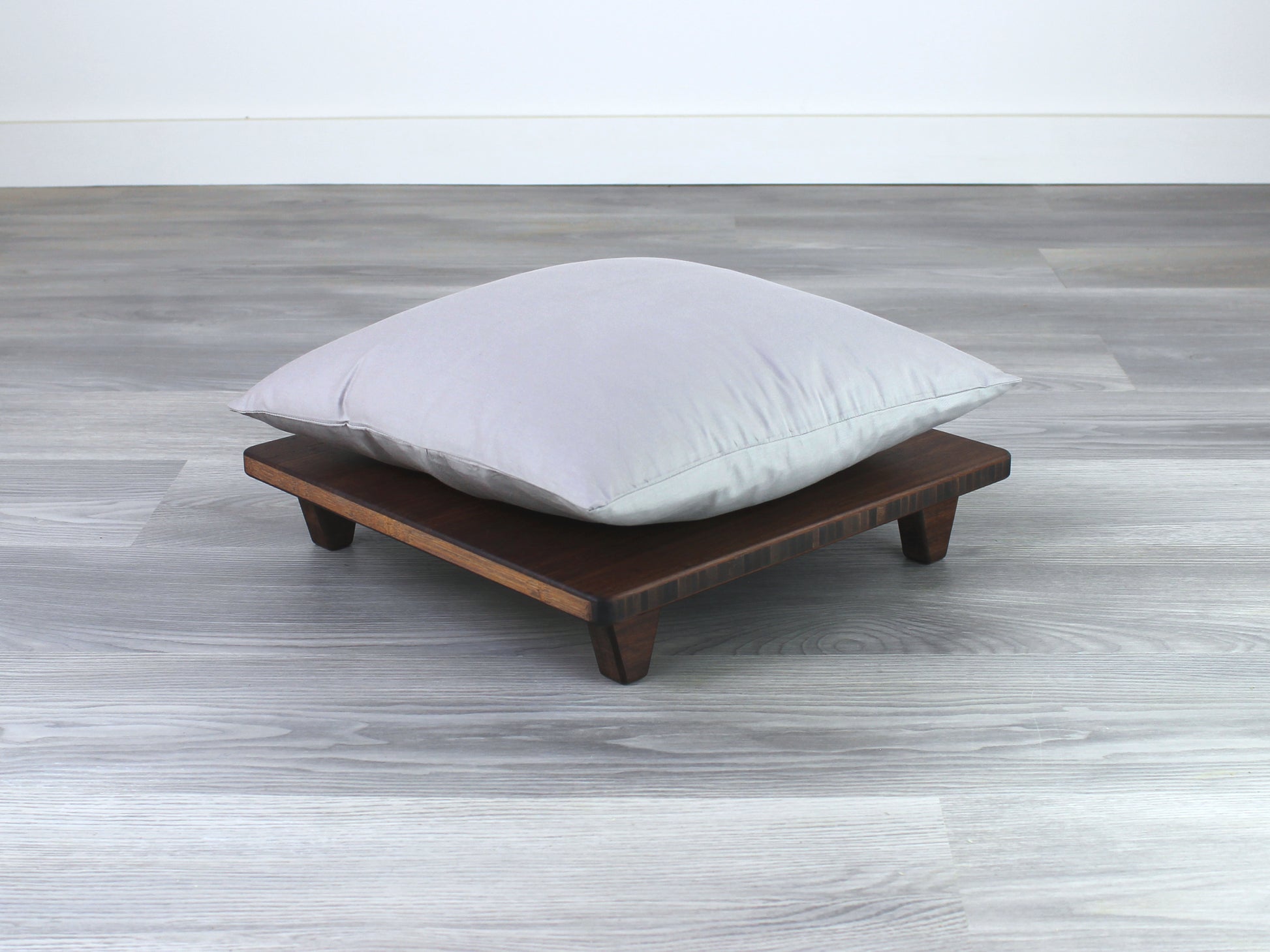 Walnut Floor Chair Posture, placed on a grey floor and a white wall background. Grey pillow placed on top. 

Meditation Chair 
Japanese Tea Table 
Kotatsu
low chair
posture support 
ergonomic 
minimilist
pillow lift