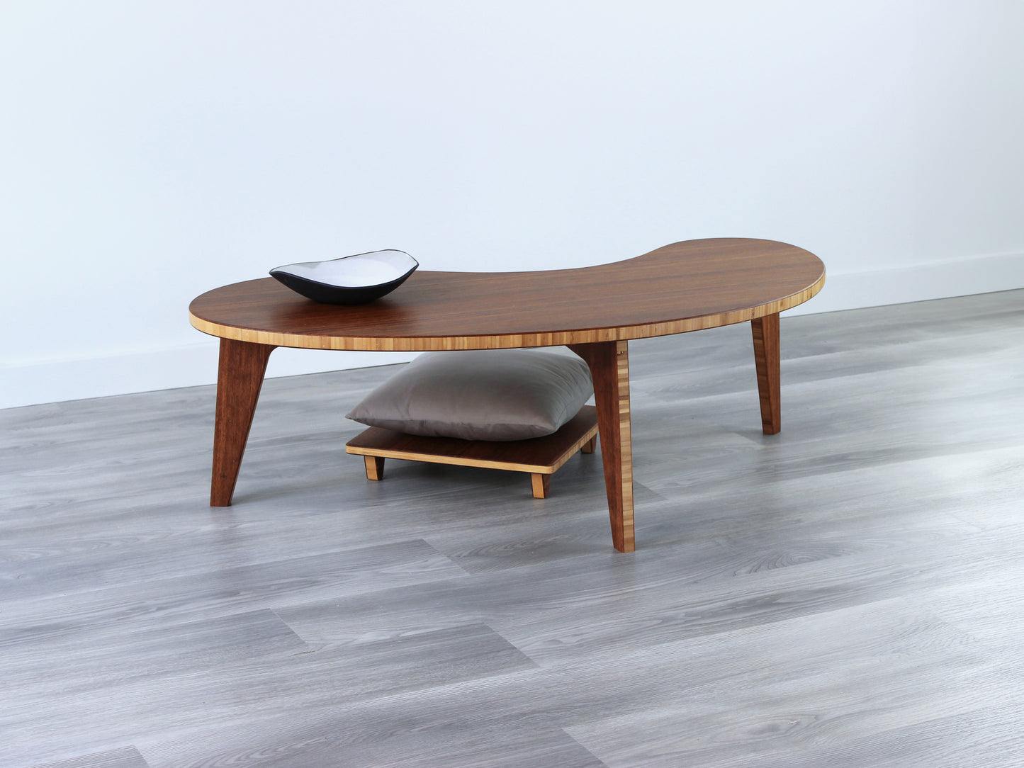 A Kidney LOW Table Set in chestnut bamboo, featuring a small black and white pottery vessel placed on top. Floor Chair Posture with a grey pillow set underneath. Placed on a Grey flooring with a white background. 

mid century modern low table
midcentury modern coffee table
floor table
japan coffee table
japan furniture
japan table
kidney coffee table 
bamboo low seating