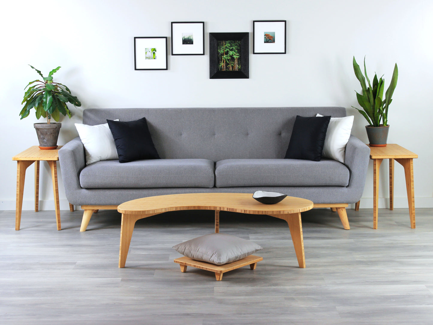 A Kidney LOW Table Set in natural bamboo, featuring a small black and white pottery vessel placed on top. Floor Chair posture with a grey pillow set underneath. Placed in a living room with grey flooring with a white background. Grey couch and houseplants on top of side tables in the background.

mid century modern low table
midcentury modern coffee table
floor table
japan coffee table
japan furniture
japan table
kidney coffee table 
bamboo low seating