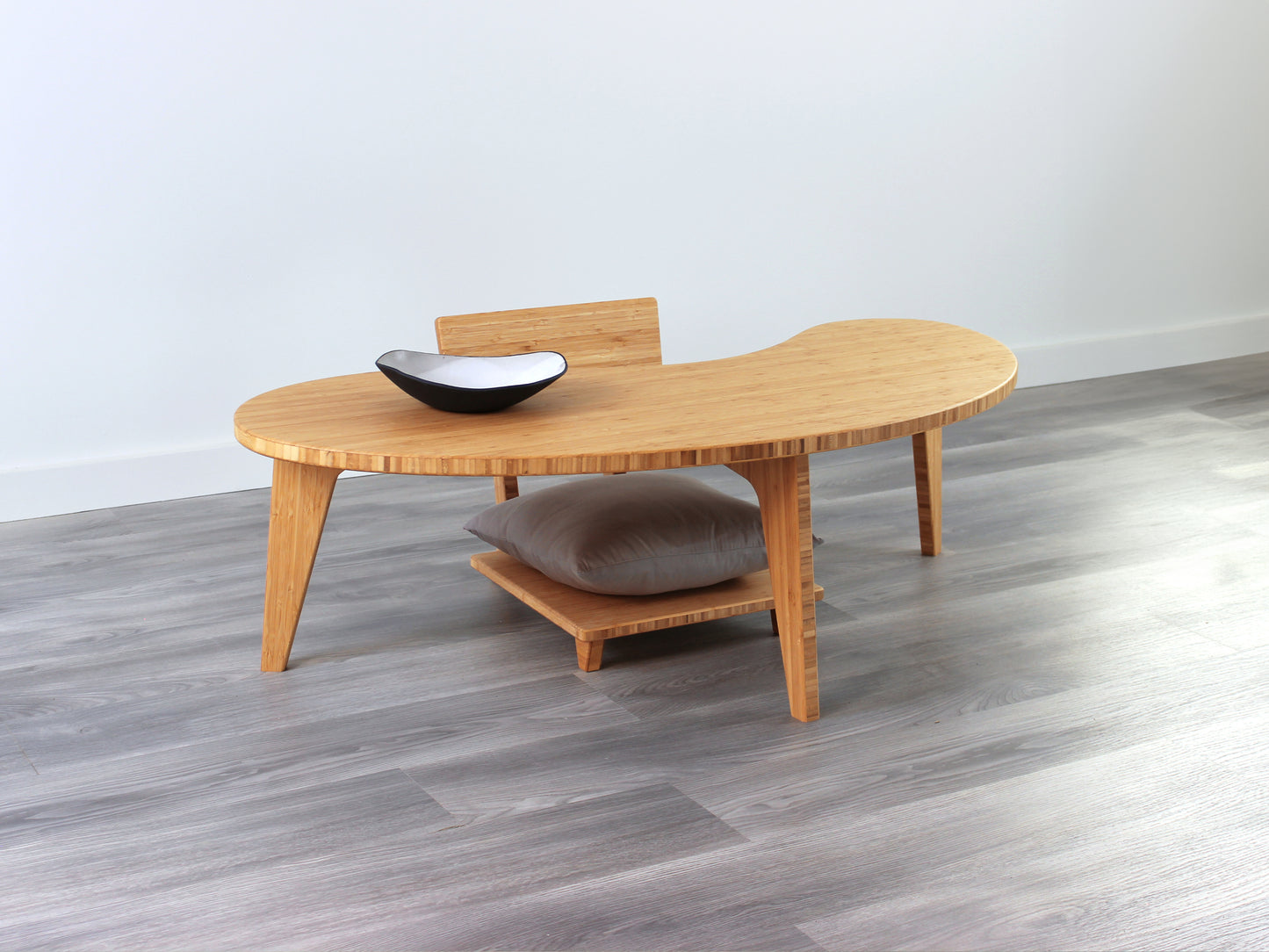 A Kidney LOW Table Set in natural bamboo, featuring a small black and white pottery vessel placed on top. Floor Chair Comfort with a grey pillow set underneath. Placed on a Grey flooring with a white background. 

mid century modern low table
midcentury modern coffee table
floor table
japan coffee table
japan furniture
japan table
kidney coffee table 
bamboo low seating