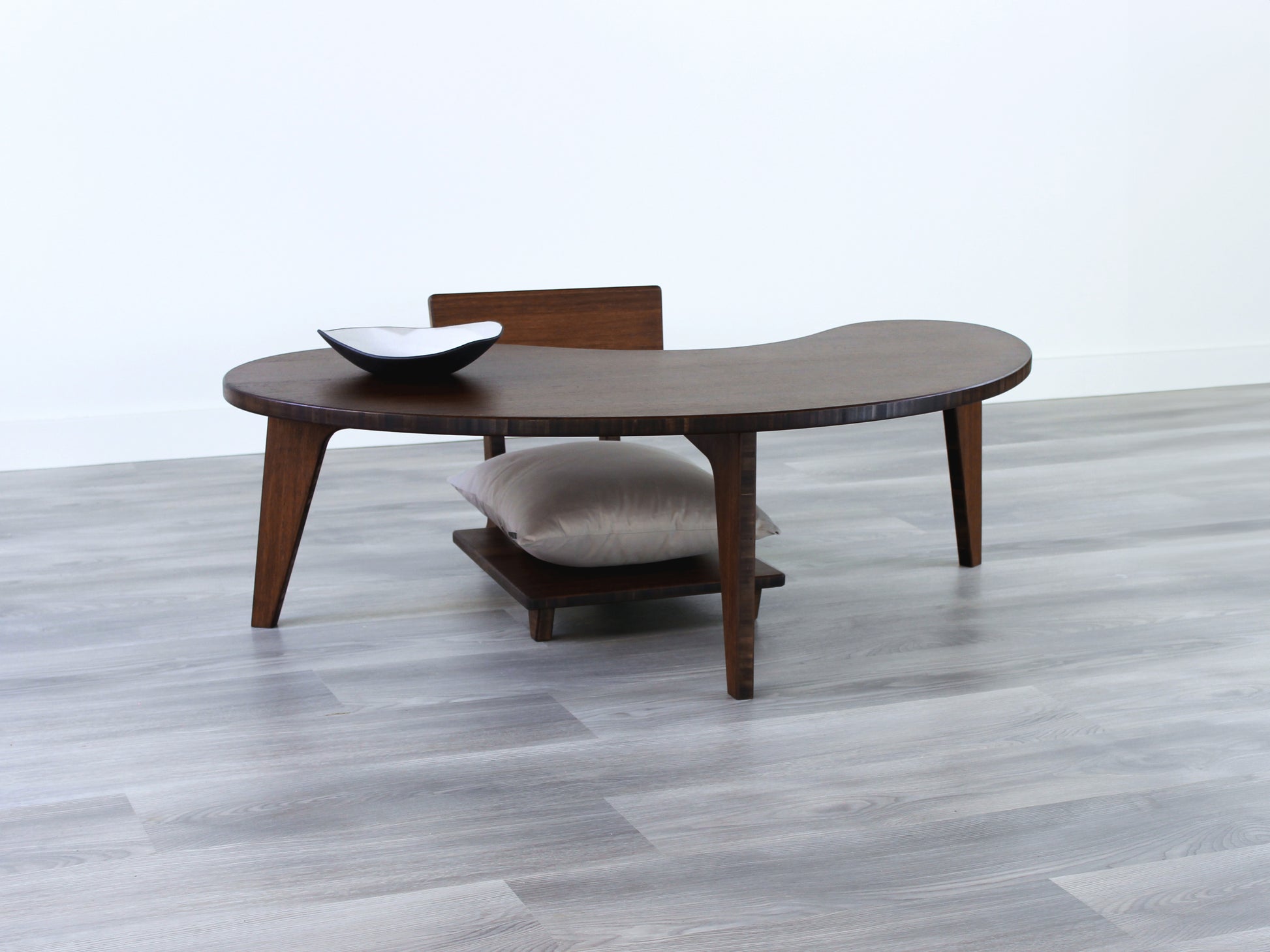 A Kidney LOW Table Set in walnut bamboo, featuring a small black and white pottery vessel placed on top. Floor Chair Comfort with a grey pillow set underneath. Placed on a Grey flooring with a white background. 

mid century modern low table
midcentury modern coffee table
floor table
japan coffee table
japan furniture
japan table
kidney coffee table 
bamboo low seating