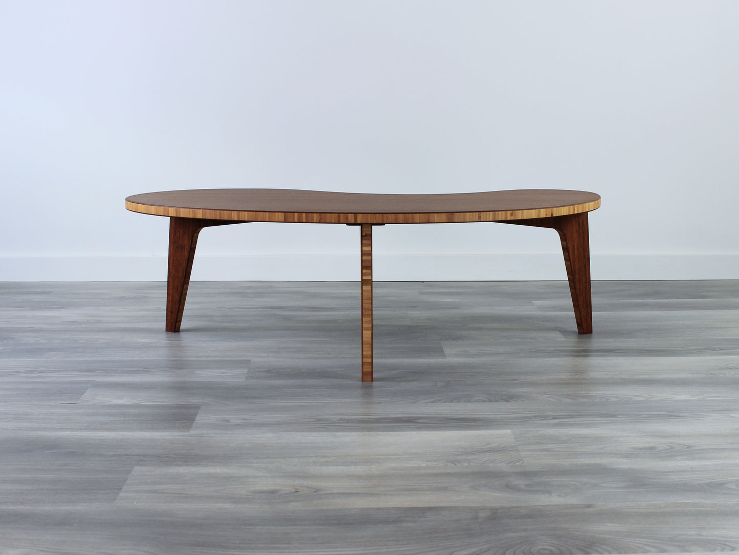 A kidney-shaped chestnut bamboo table. Grey flooring with a white background. 

mid century modern low table
midcentury modern coffee table
floor table
japan coffee table
japan furniture
japan table
kidney coffee table 
bamboo low table