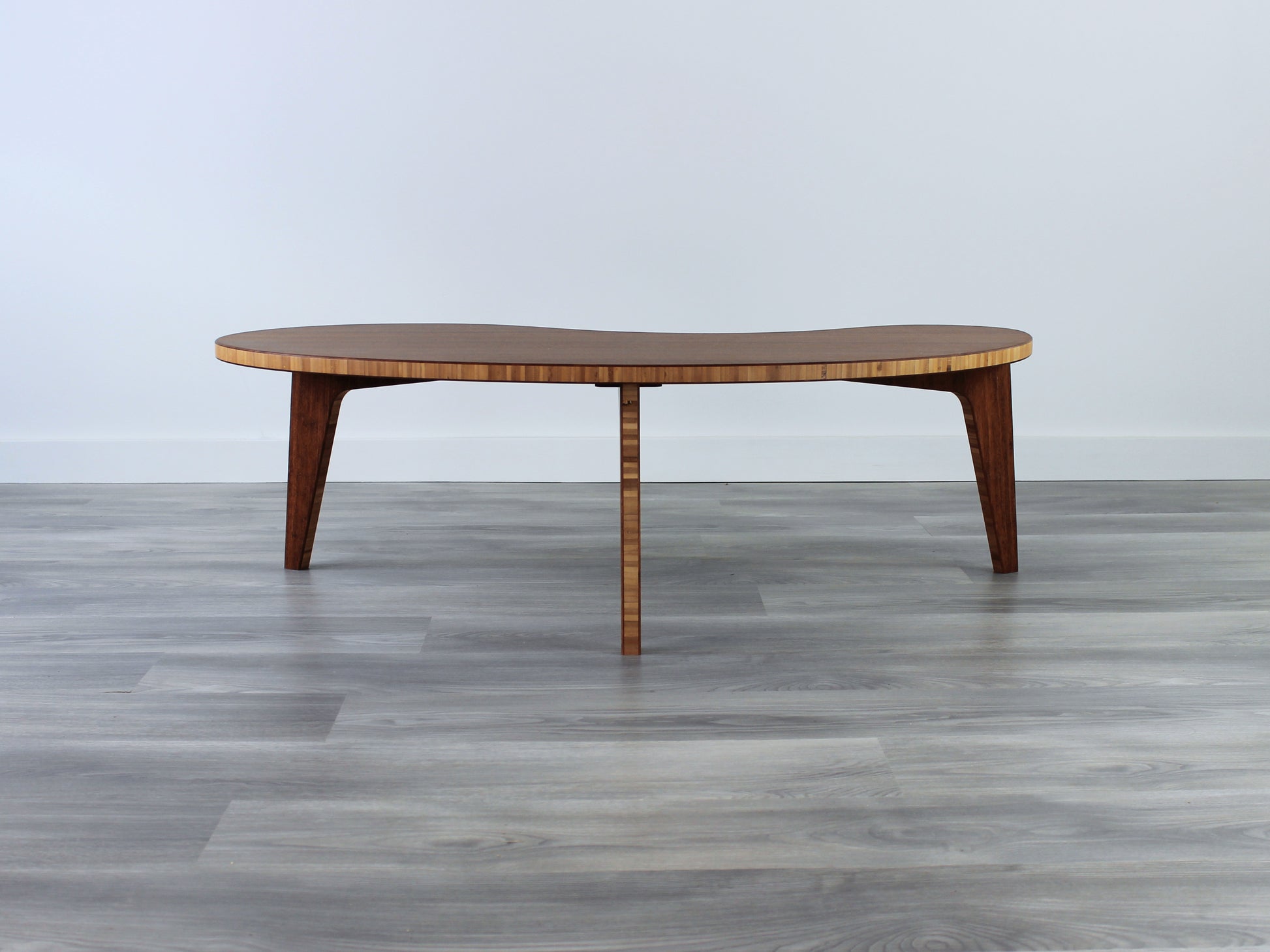 A kidney-shaped chestnut bamboo table. Grey flooring with a white background. 

mid century modern low table
midcentury modern coffee table
floor table
japan coffee table
japan furniture
japan table
kidney coffee table 
bamboo low table
