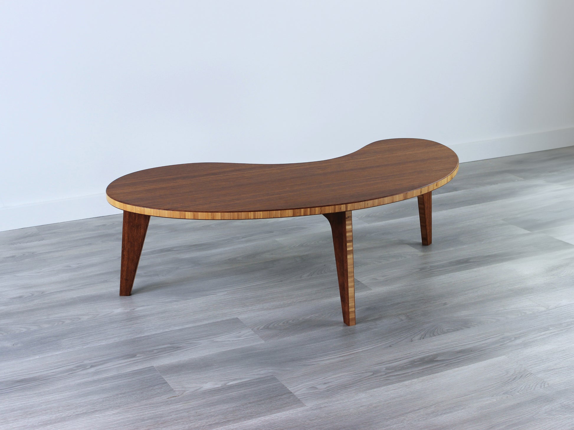 A kidney-shaped chestnut bamboo table. Grey flooring with a white background. 

mid century modern low table
midcentury modern coffee table
floor table
japan coffee table
japan furniture
japan table
kidney coffee table 
bamboo low table