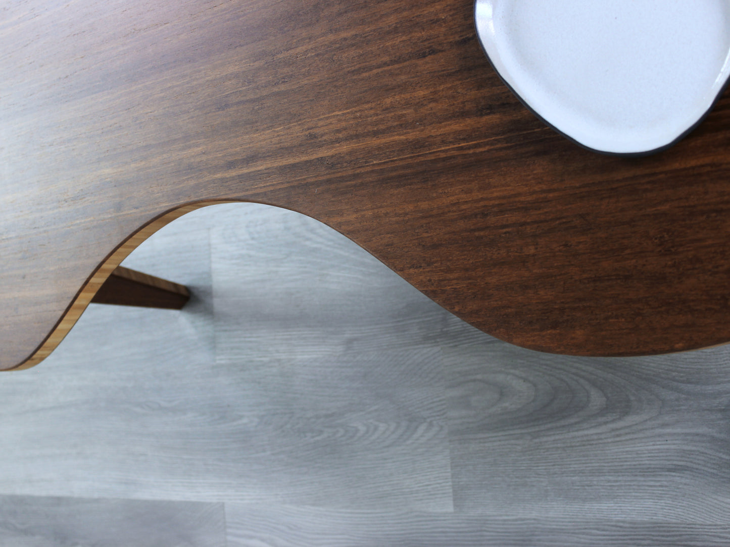 A kidney-shaped chestnut bamboo table, featuring a small black and white pottery vessel placed on top. Grey flooring with a white background. 

mid century modern low table
midcentury modern coffee table
floor table
japan coffee table
japan furniture
japan table
kidney coffee table 
bamboo low table