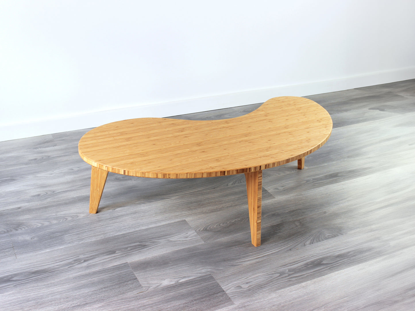 A kidney-shaped natural bamboo table. Grey flooring with a white background. 

mid century modern low table
midcentury modern coffee table
floor table
japan coffee table
japan furniture
japan table
kidney coffee table 
bamboo low table