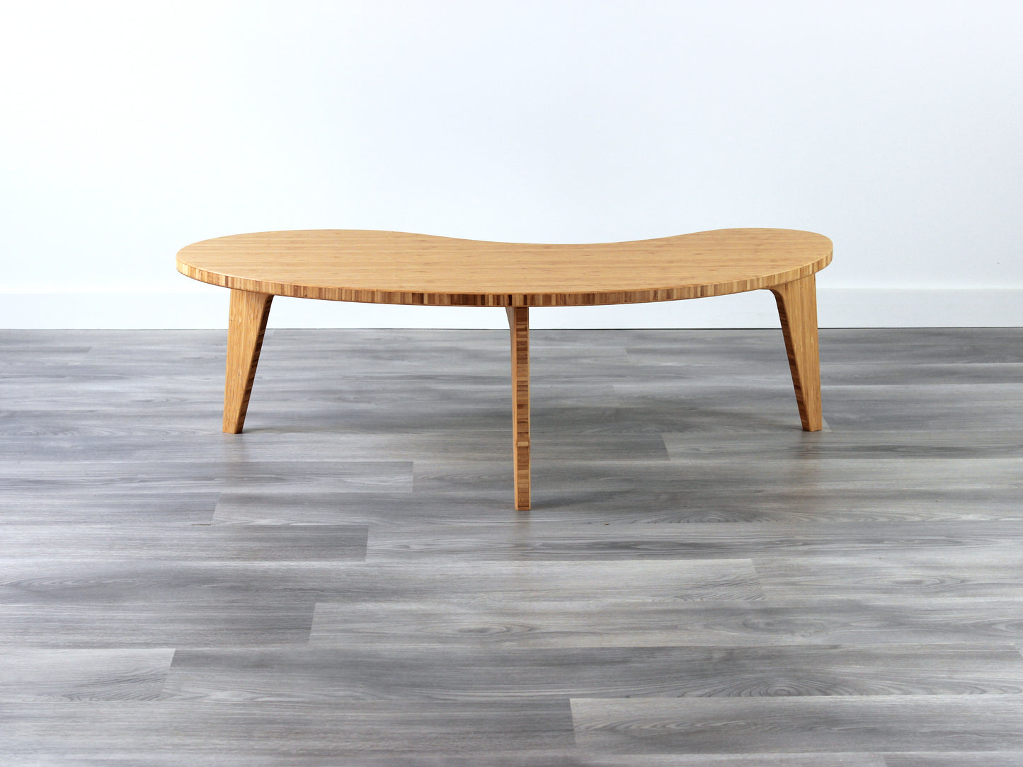 A kidney-shaped natural bamboo table. Grey flooring with a white background. 

mid century modern low table
midcentury modern coffee table
floor table
japan coffee table
japan furniture
japan table
kidney coffee table 
bamboo low table