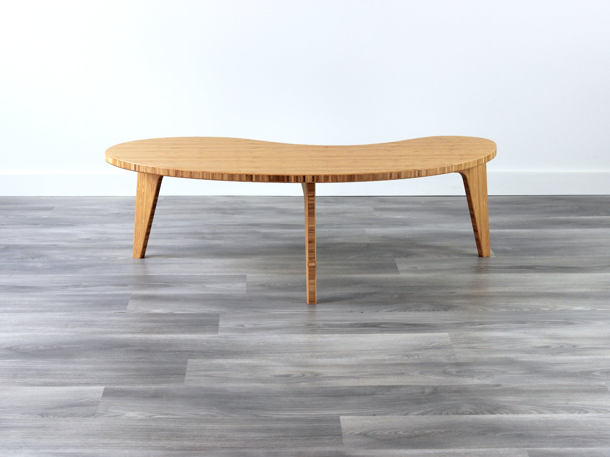 A kidney-shaped natural bamboo table. Grey flooring with a white background. 

mid century modern low table
midcentury modern coffee table
floor table
japan coffee table
japan furniture
japan table
kidney coffee table 
bamboo low table
