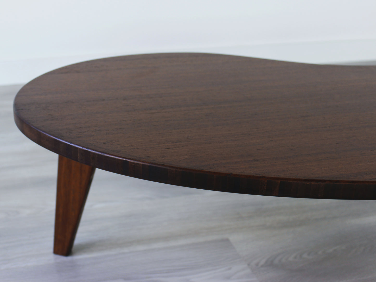 A kidney-shaped walnut bamboo table. Grey flooring with a white background. 

mid century modern low table
midcentury modern coffee table
floor table
japan coffee table
japan furniture
japan table
kidney coffee table 
bamboo low table