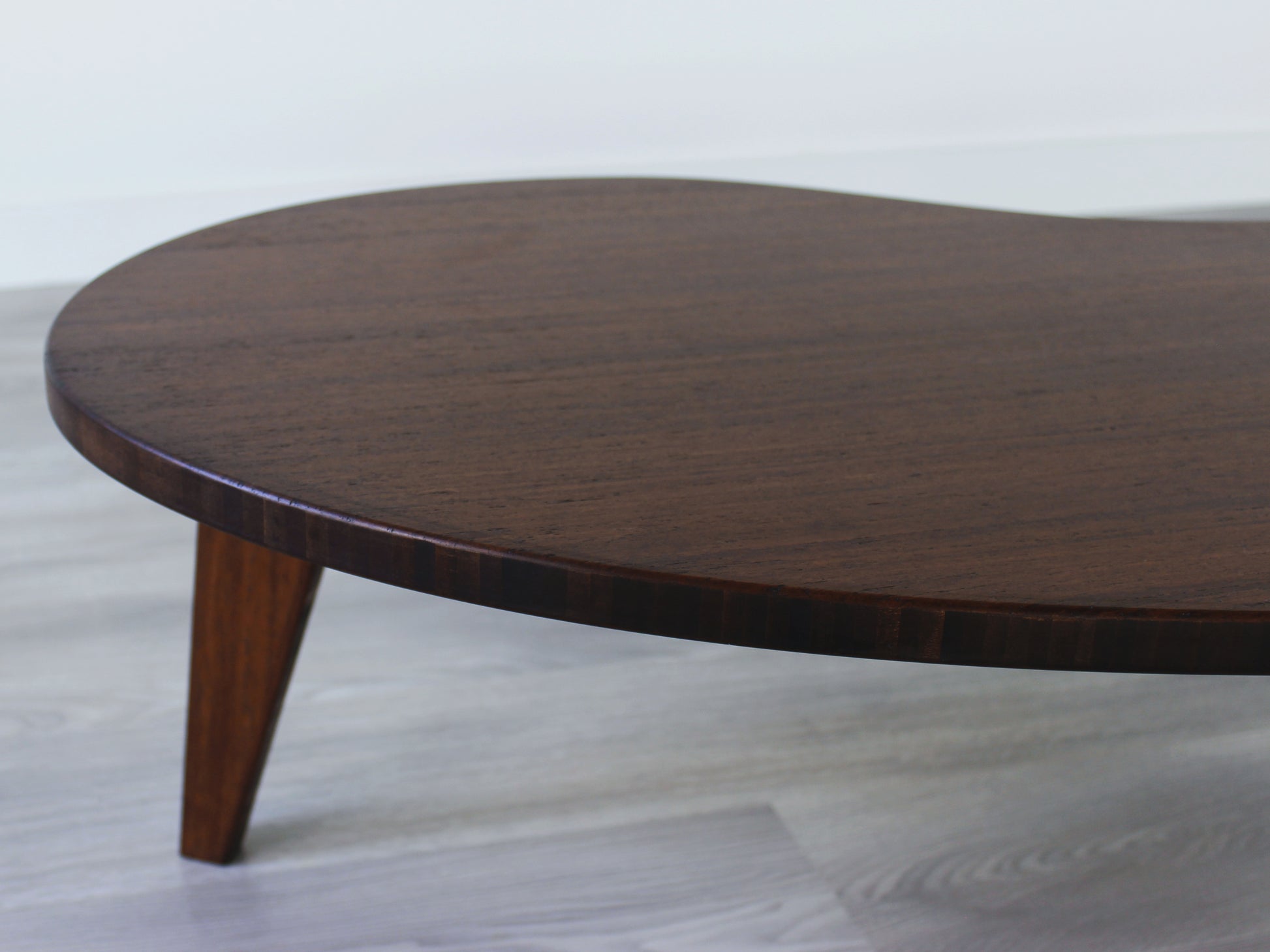 A kidney-shaped walnut bamboo table. Grey flooring with a white background. 

mid century modern low table
midcentury modern coffee table
floor table
japan coffee table
japan furniture
japan table
kidney coffee table 
bamboo low table