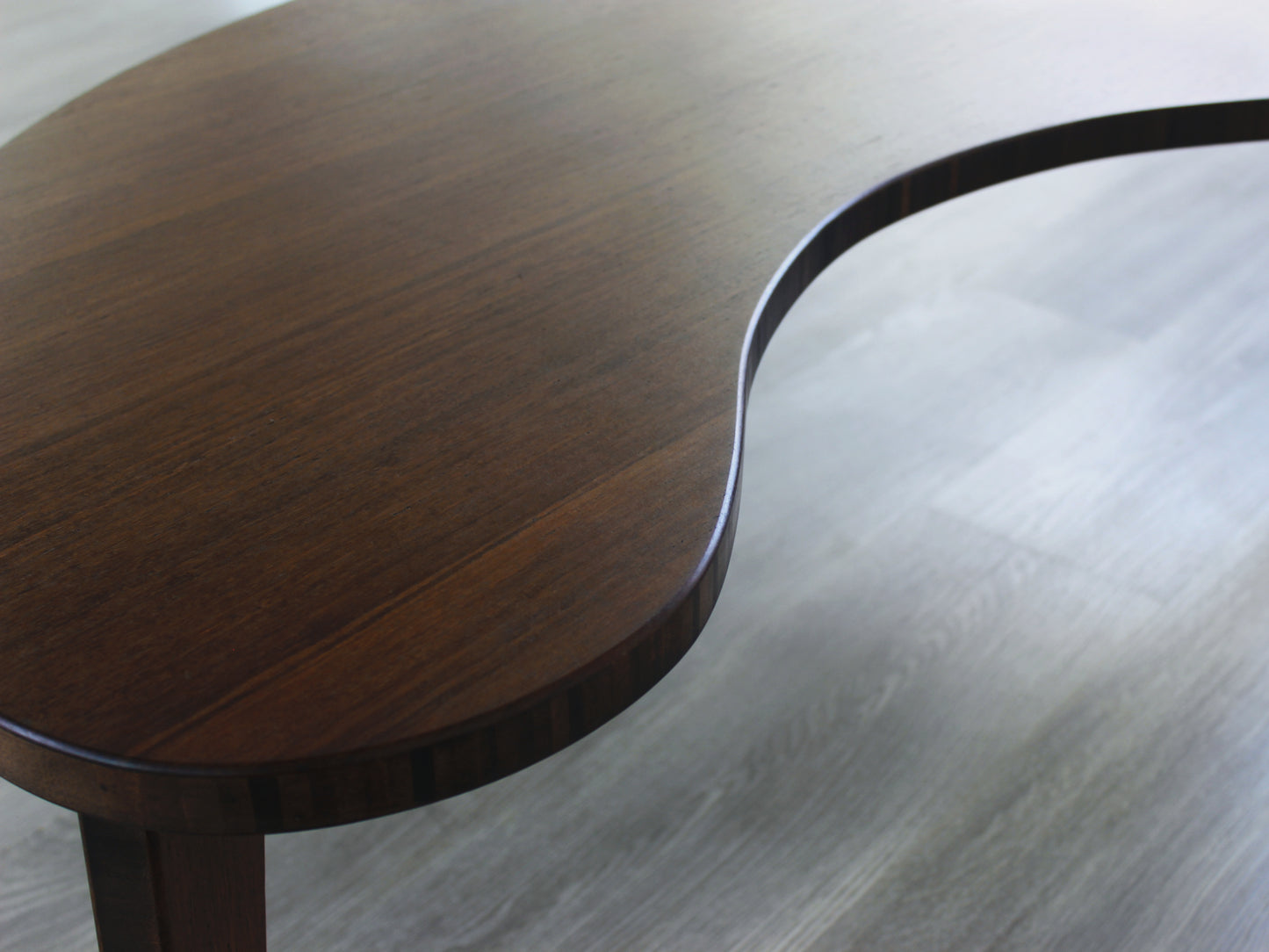 A kidney-shaped walnut bamboo table. Grey flooring with a white background. 

mid century modern low table
midcentury modern coffee table
floor table
japan coffee table
japan furniture
japan table
kidney coffee table 
bamboo low table