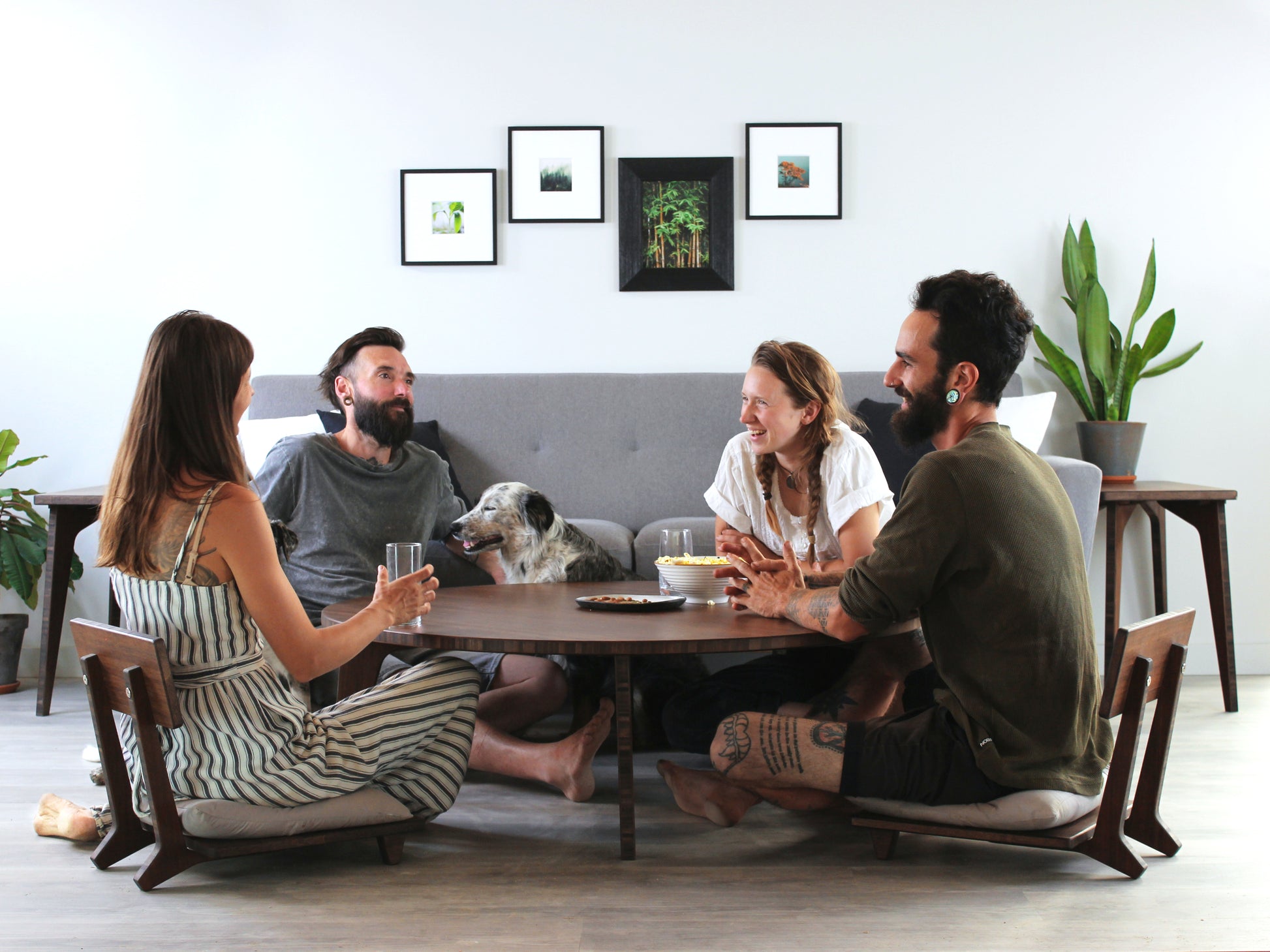 Large Circle Low Table with a walnut bamboo finish and midcentury modern design. People sitting in Floor Chair Comforts with a grey pillow are set at the table. Small black pottery vessel placed on table top. 

Japandi, minimalist, mid-century, Japanese inspired, modern, contemporary, clean lines, organic design, sustainable bamboo, renewable bamboo, solid bamboo, eco-friendly furniture, natural materials, natural-based finish