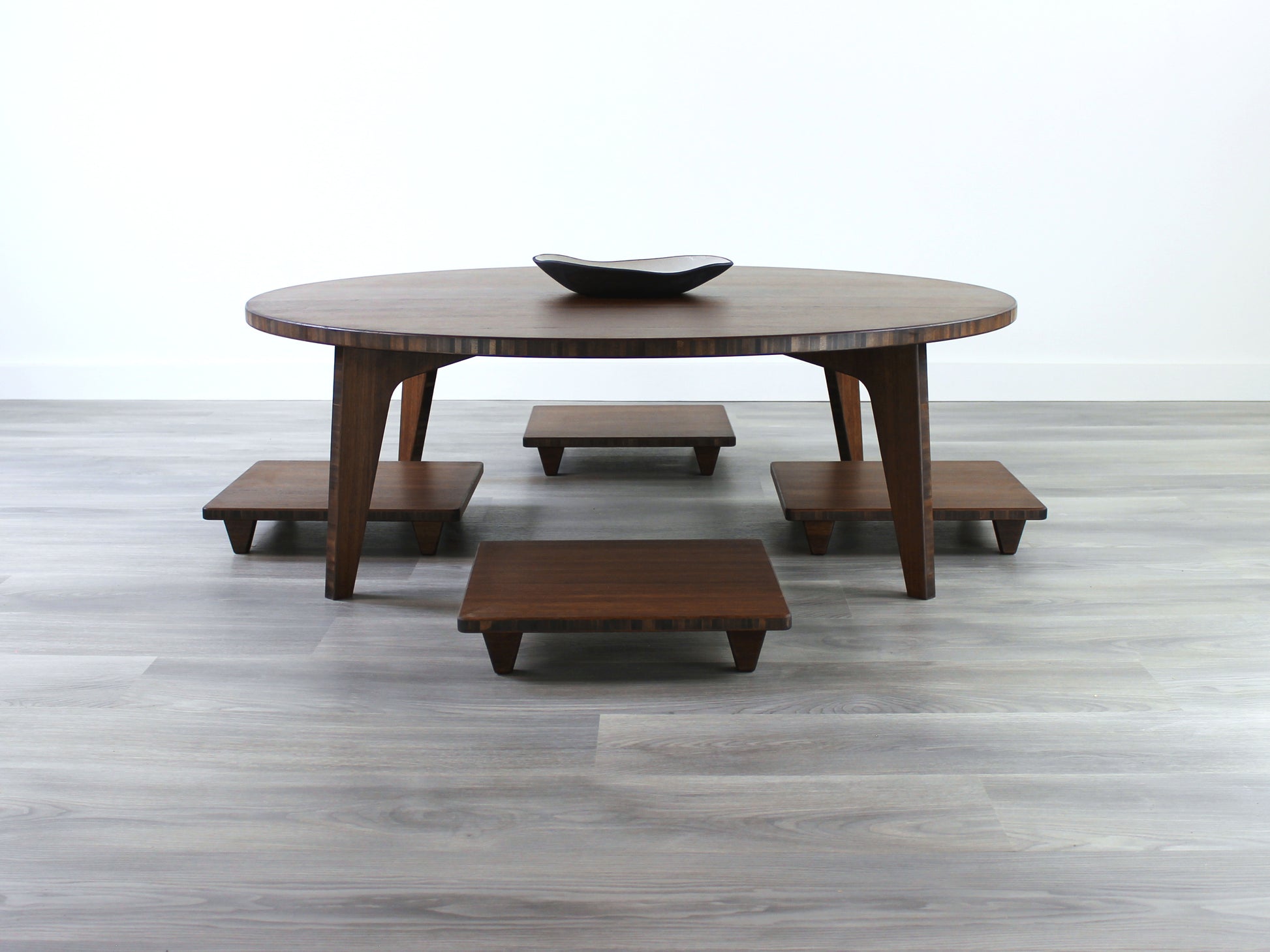 Large Circle Low Table with a walnut bamboo finish and midcentury modern design. Floor Chair Posture with a grey pillow are set at the table, small black pottery vessel placed on table top. 

Japandi, minimalist, mid-century, Japanese inspired, modern, contemporary, clean lines, organic design, sustainable bamboo, renewable bamboo, solid bamboo, eco-friendly furniture, natural materials, natural-based finish