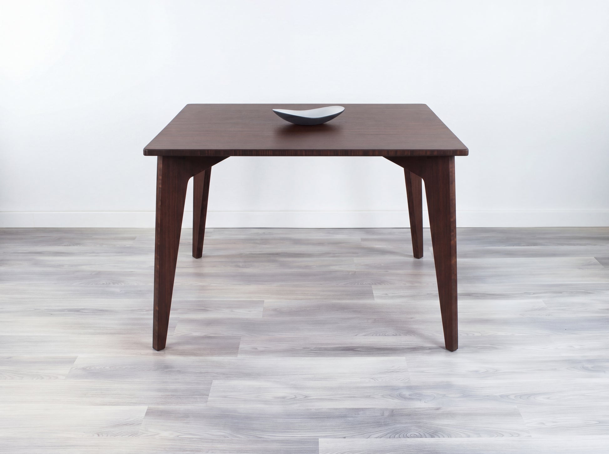 Bamboo table with a white wall and gray floor in the background