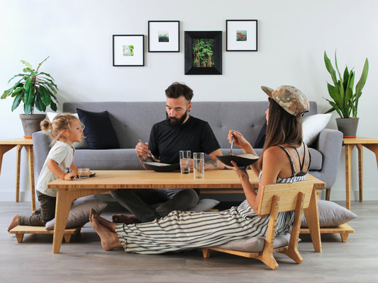 Large Rectangle Table Set - Natural low table with Floor Chair Posture and Comfort with grey pillows placed underneath. Living room setting, grey couch. Set on a grey floor, against a white background. Multiple small black pottery vessels are on the table top. 

low table, coffee table, dining table, floor desk, floor chair, floor seating, low dining table, chabudai, tatami, kotatsu, minimalist, minimalist table,
modern, japanese low table, japanese table, kotatsu, large coffee table,
large dining table
