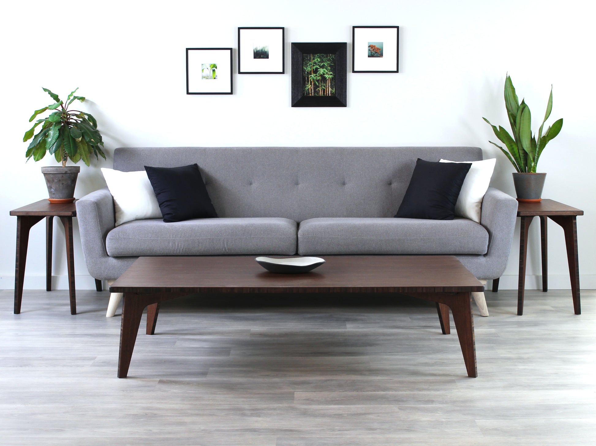 A large rectangular low table made of bamboo with a walnut finish, placed on a grey floor, designed for multi-functional use in living spaces. A small black pottery vessel set on the table top. Small black pottery vessel on table top. Set in a living room setting with a grey couch and two Side Tables with houseplants. 

japanese furniture
japanese low table
low coffee table
low dining table
low table
mid century
minimalist
minimalist table
modern