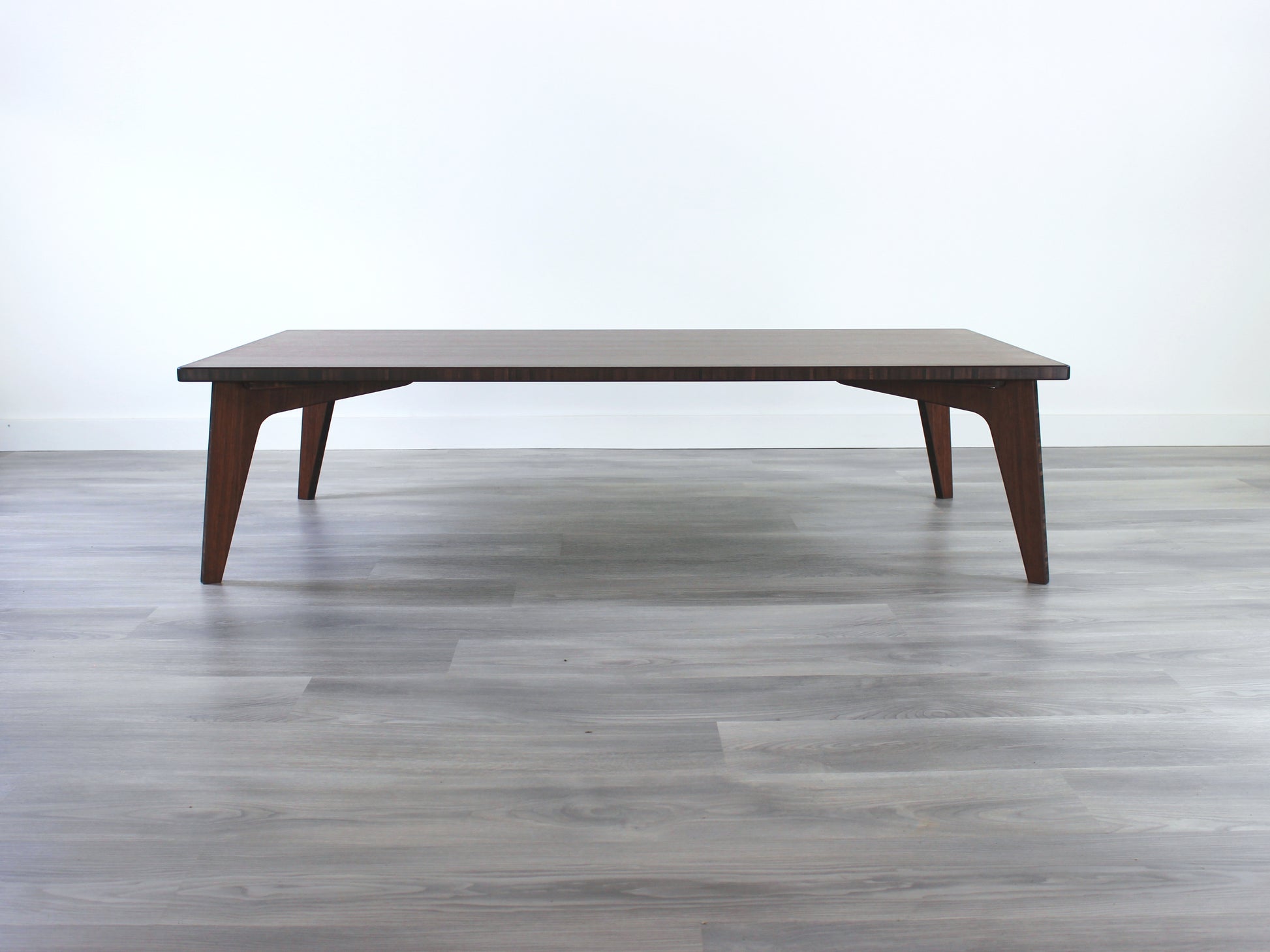 A large rectangular low table made of bamboo with a walnut finish, placed on a grey floor, designed for multi-functional use in living spaces. 

japanese furniture
japanese low table
low coffee table
low dining table
low table
mid century
minimalist
minimalist table
modern