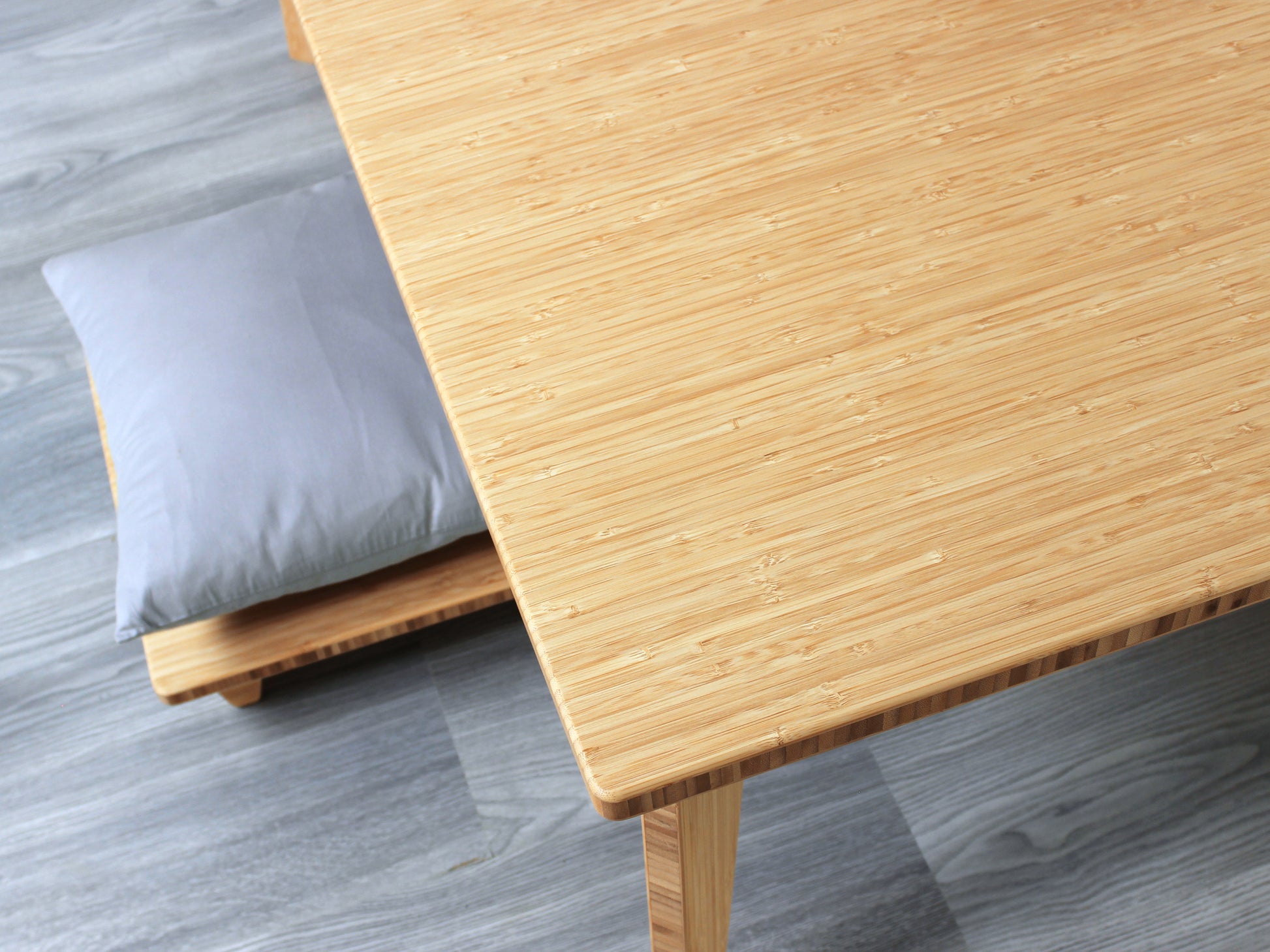 Large square floor table in bamboo with a Natural color finish, featuring a Japandi style design, set on a grey floor with a white background. A small black pottery vessel sets on top. Floor Chair Posture is set underneath.

Square low table 
japanese furniture
japanese low table
low coffee table
low dining table
low table
mid century
minimalist
minimalist table
modern
chabudai
Floor Chair Posture with a grey pillow is set underneath
