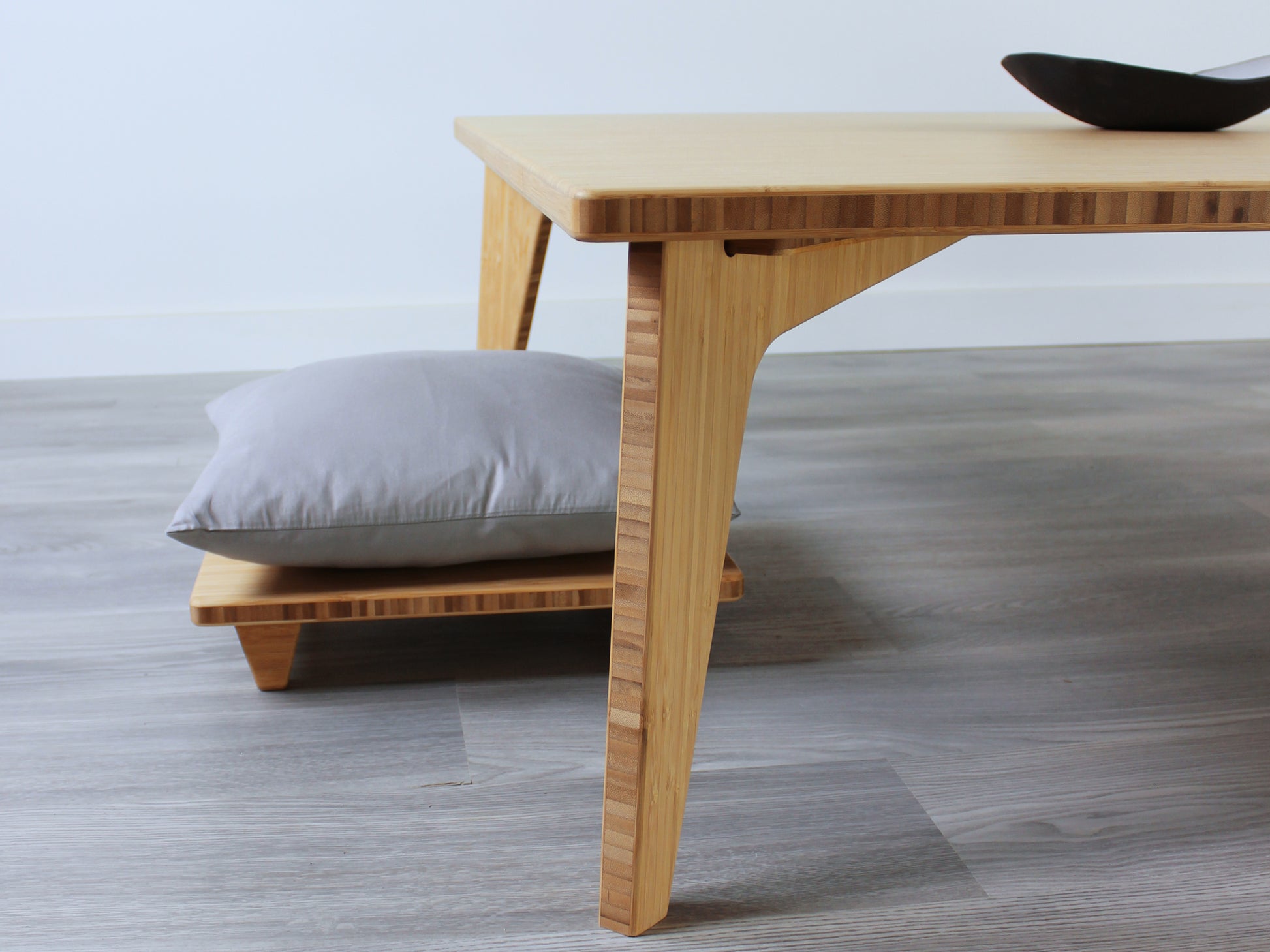Large square floor table in bamboo with a natural color finish, featuring a Japandi style design, set on a grey floor with a white background. A small black pottery vessel sets on top. Floor Chair Posture is set underneath.

Square low table 
japanese furniture
japanese low table
low coffee table
low dining table
low table
mid century
minimalist
minimalist table
modern
chabudai
Floor Chair Posture with a grey pillow is set underneath